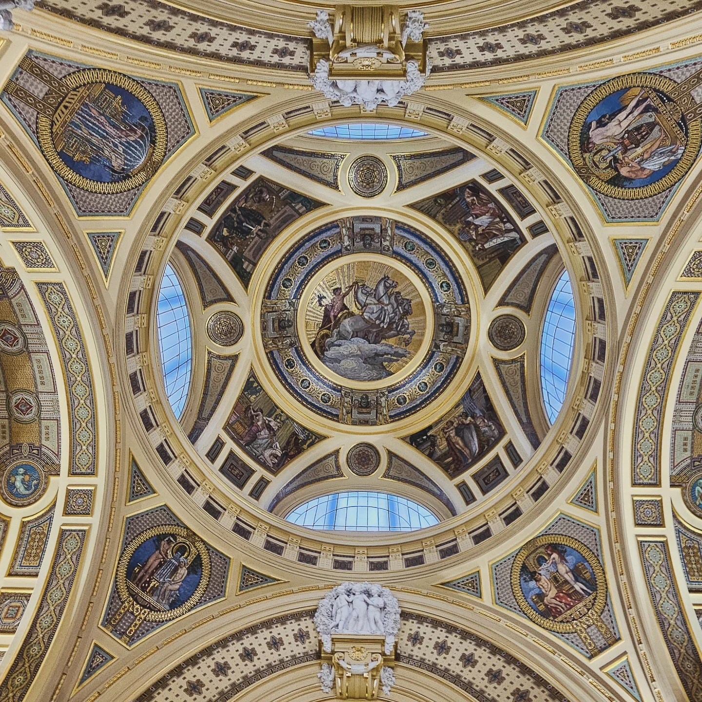 Elaborate golden dome ceiling with mosaics and religious artwork inside Széchenyi Thermal Bath.