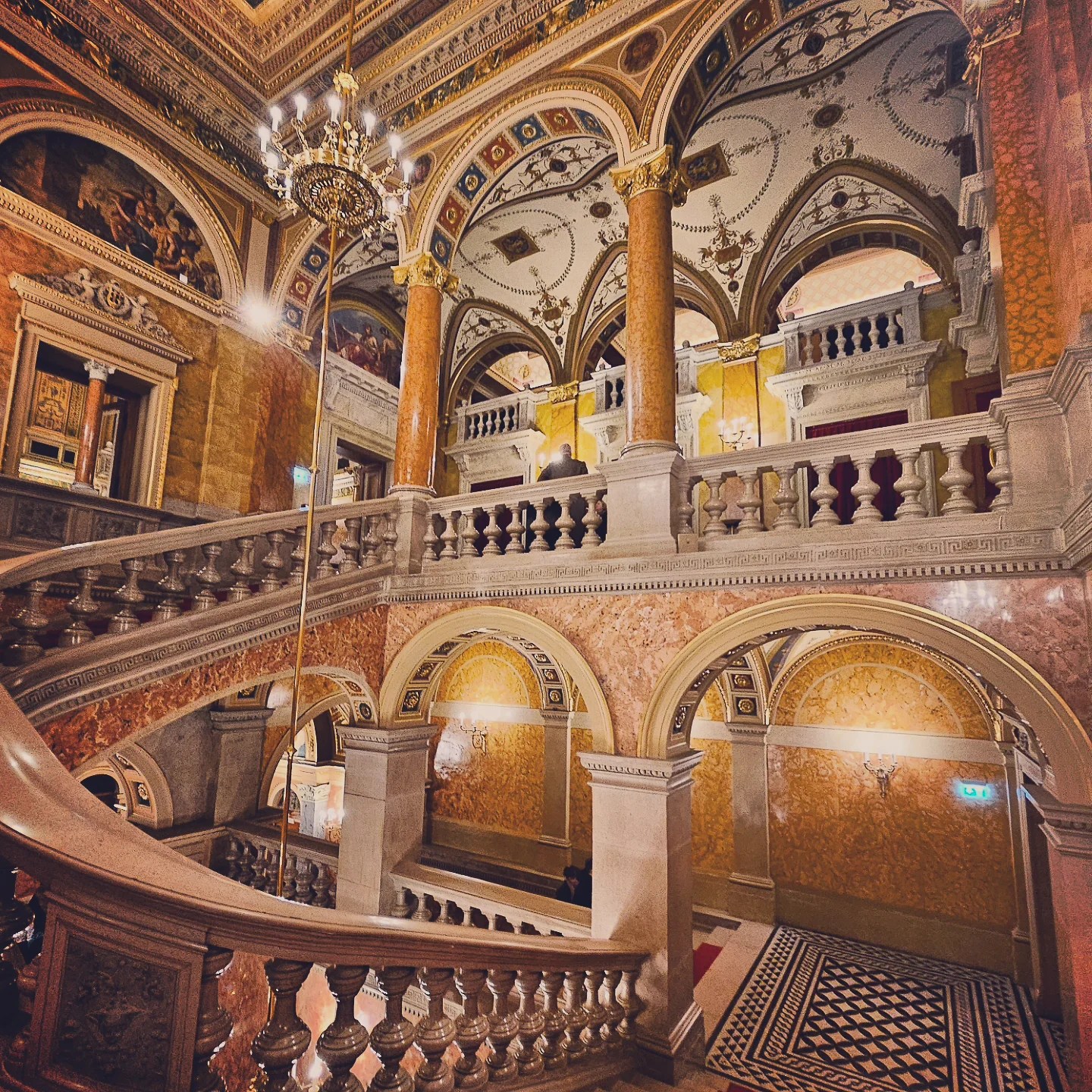 Layered arches and balconies inside the richly decorated Hungarian State Opera House, with golden hues and classical columns.