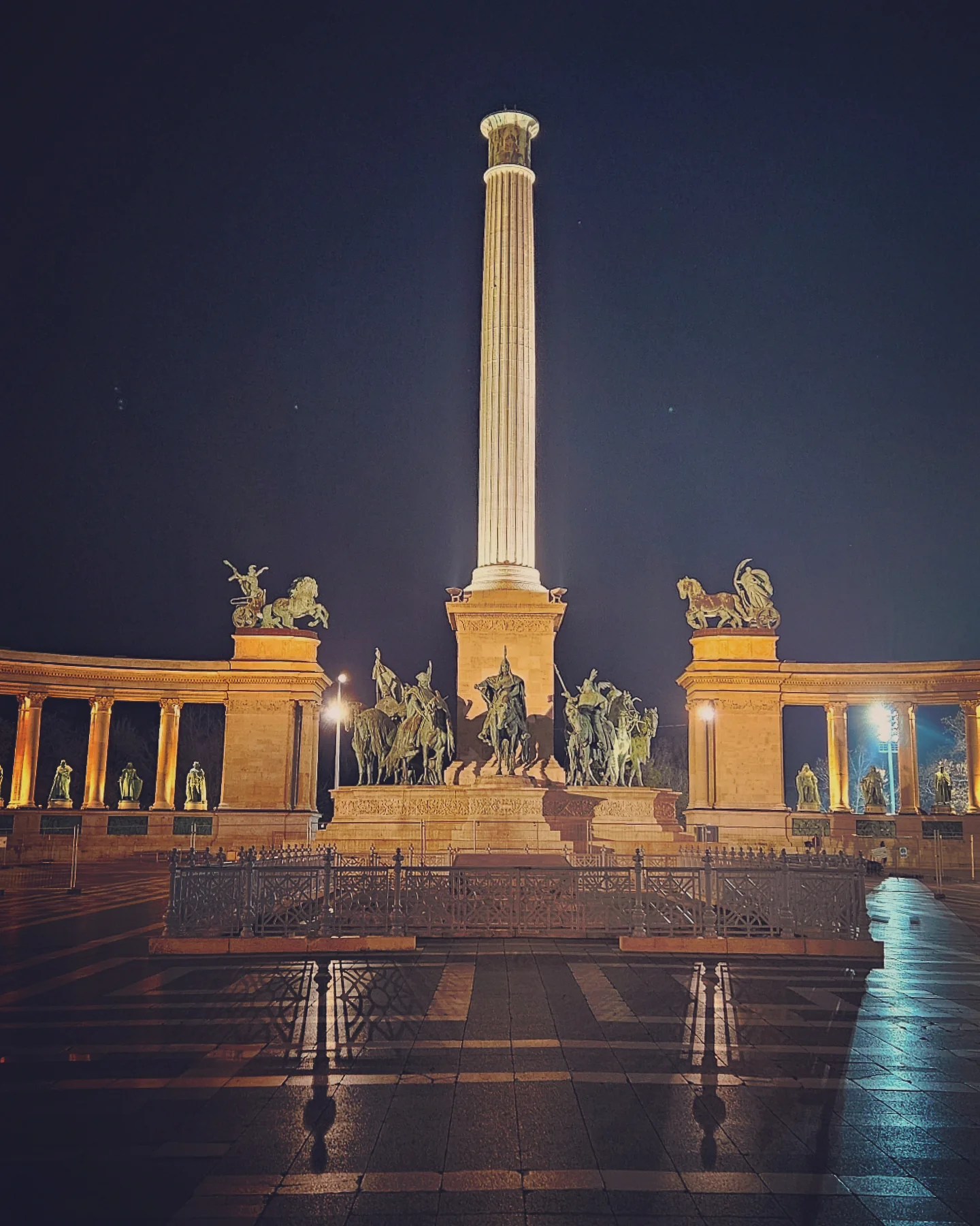Millennium Monument in Heroes’ Square, Budapest, illuminated at night with statues of Hungarian leaders.