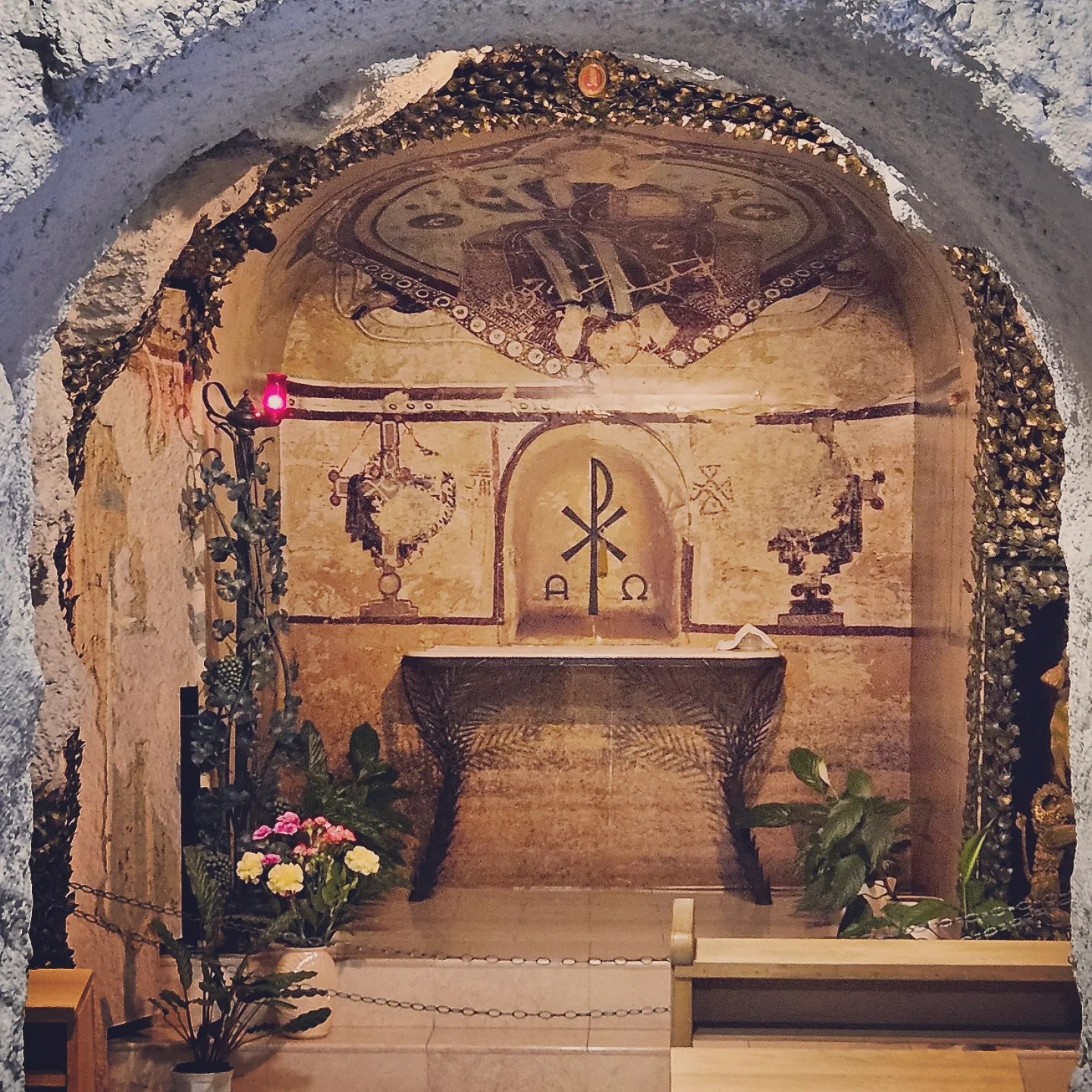 Ornate niche in the Cave Church with early Christian symbols and floral decorations.
