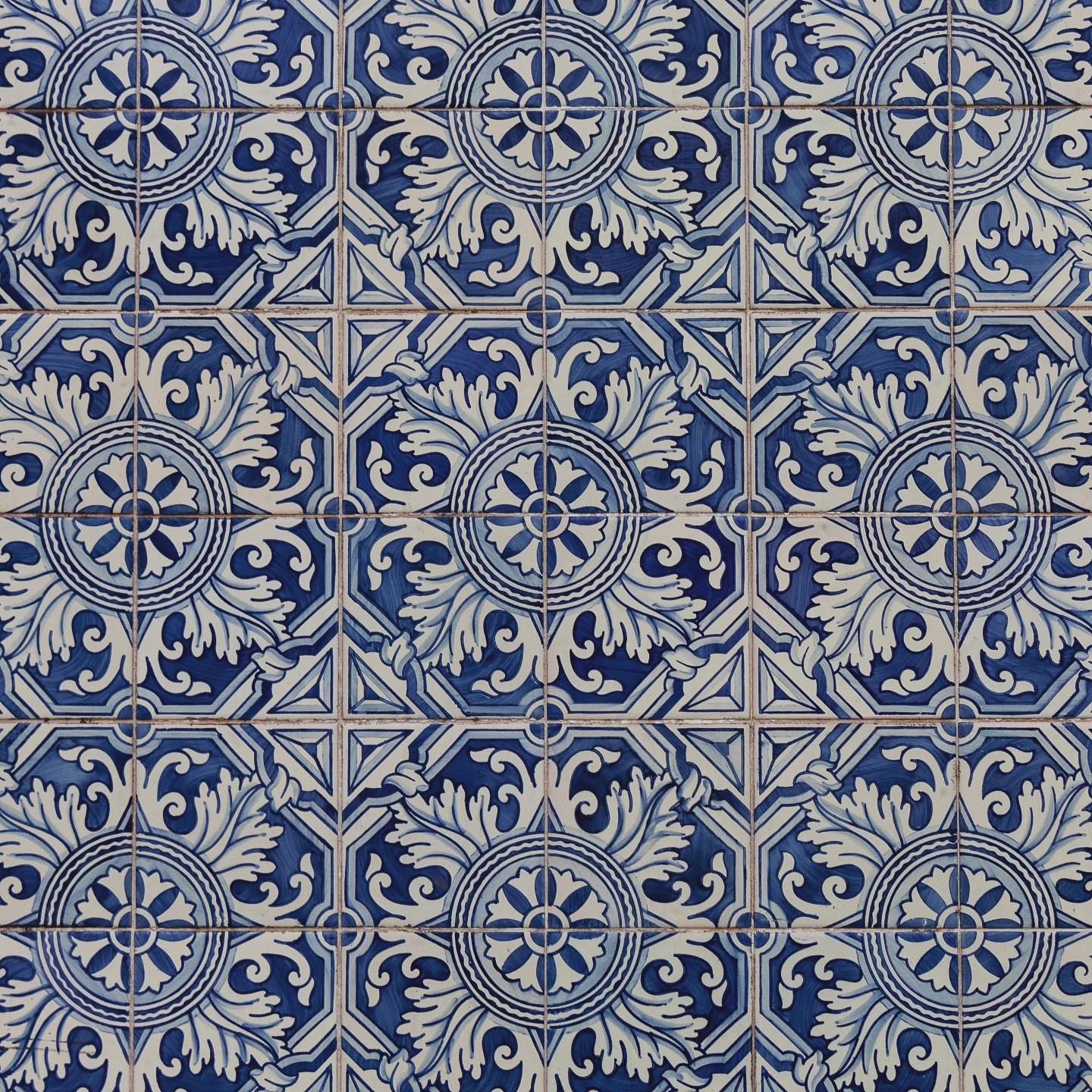 Close-up of traditional Portuguese blue and white azulejo tiles with an ornate floral pattern.