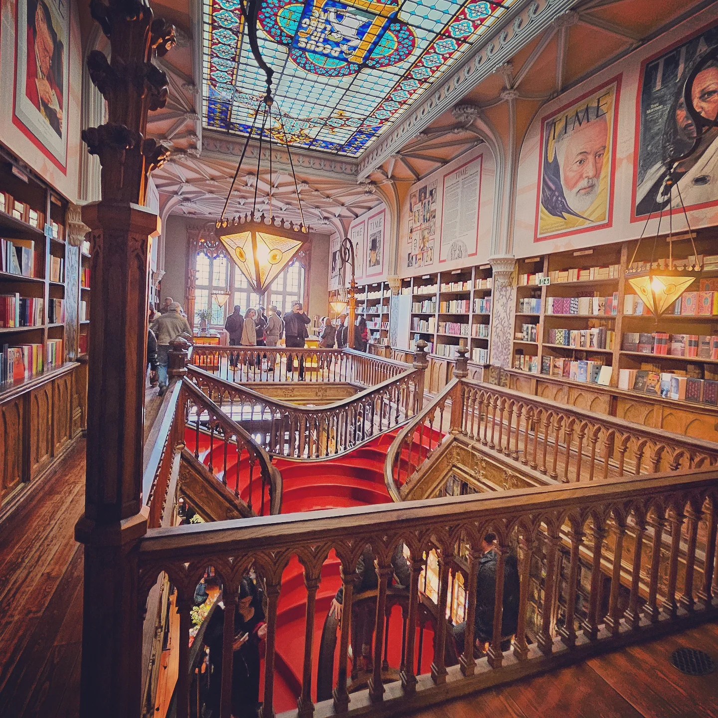 Interior of Livraria Lello bookstore with its famous red staircase and stained glass ceiling.