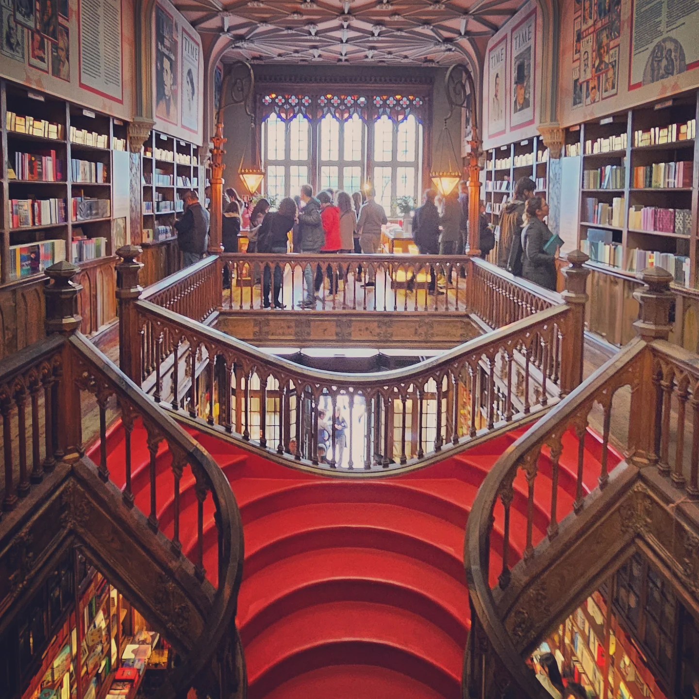 Iconic red double staircase inside Livraria Lello bookstore, viewed from the balcony above.