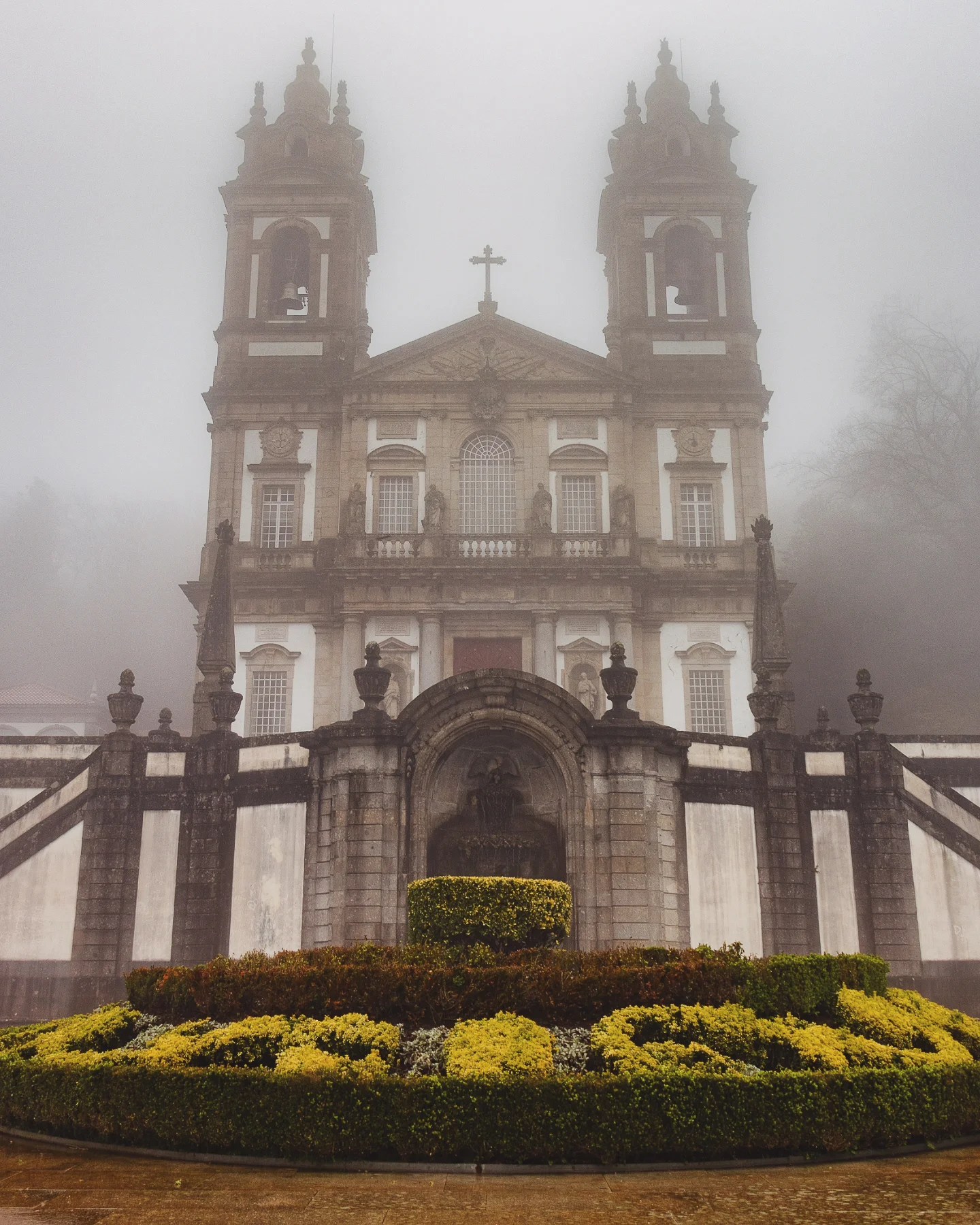 Front view of the Sanctuary of Bom Jesus do Monte with terraced gardens and fog in Braga, Portugal.