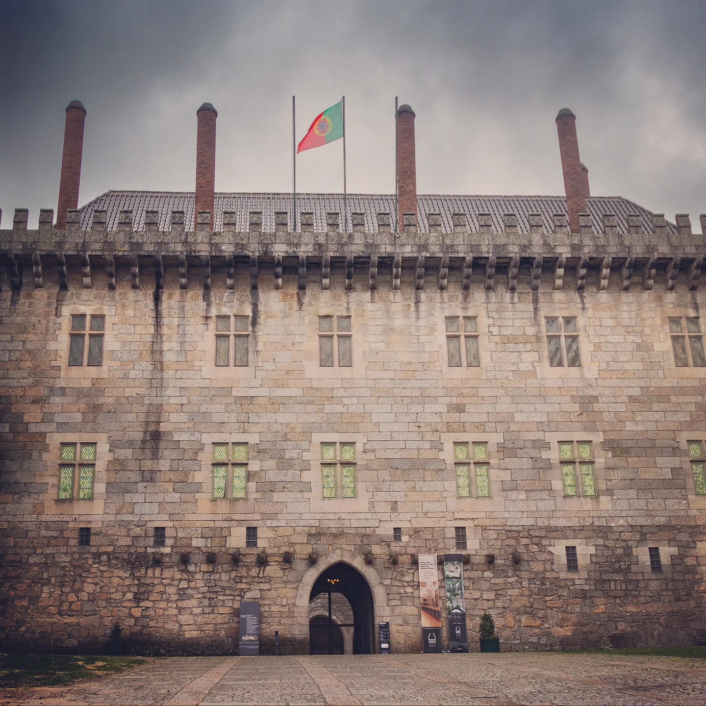 Front façade of the Palace of the Dukes of Braganza with the Portuguese flag flying above.