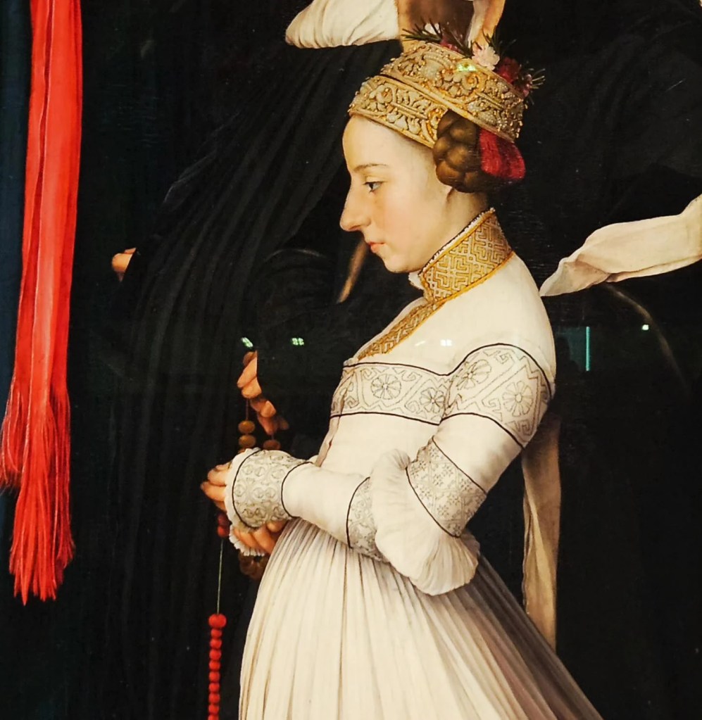 A detailed part of a painting of a young woman in elaborate medieval attire, wearing an embroidered headdress and holding a string of red prayer beads, part of the art collection at the Johanniterkirche Museum in Schwäbisch Hall.