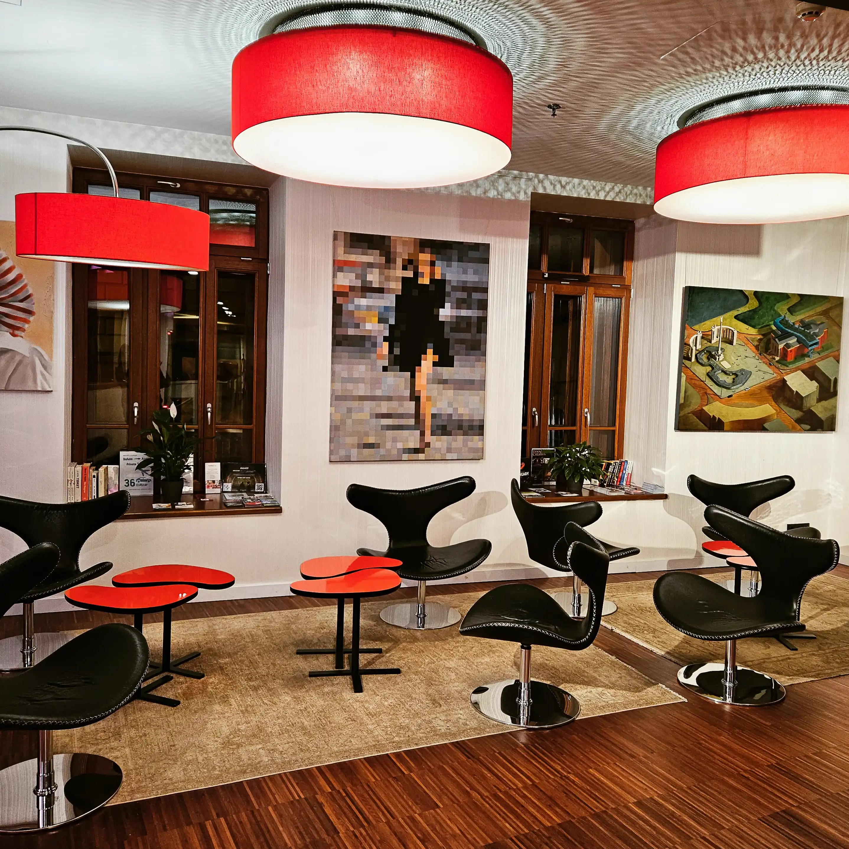 Lounge area with red lighting and modern artwork in a Budapest hotel.