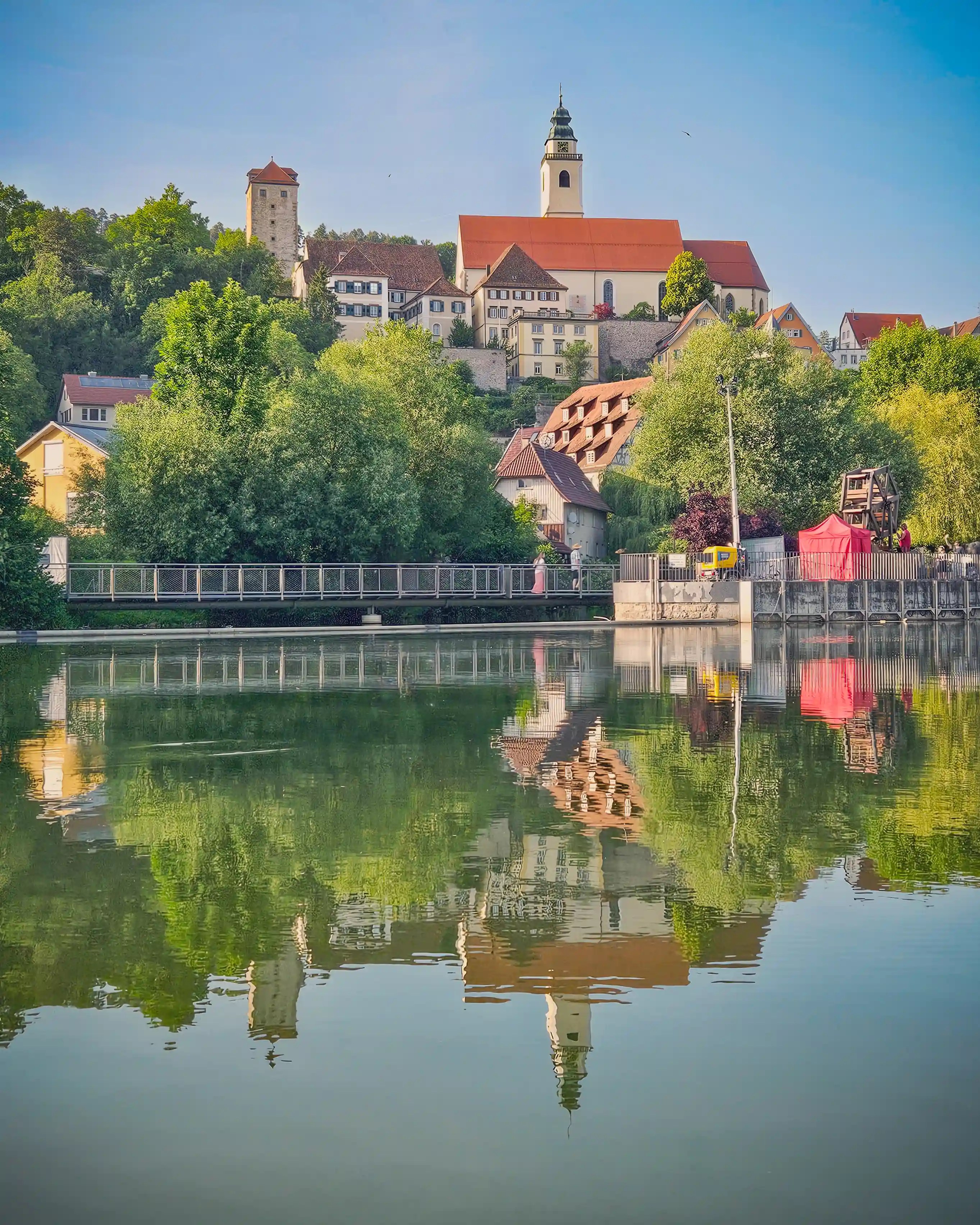 The historic skyline of Horb am Neckar and its church reflected in the still waters of the Neckar River.