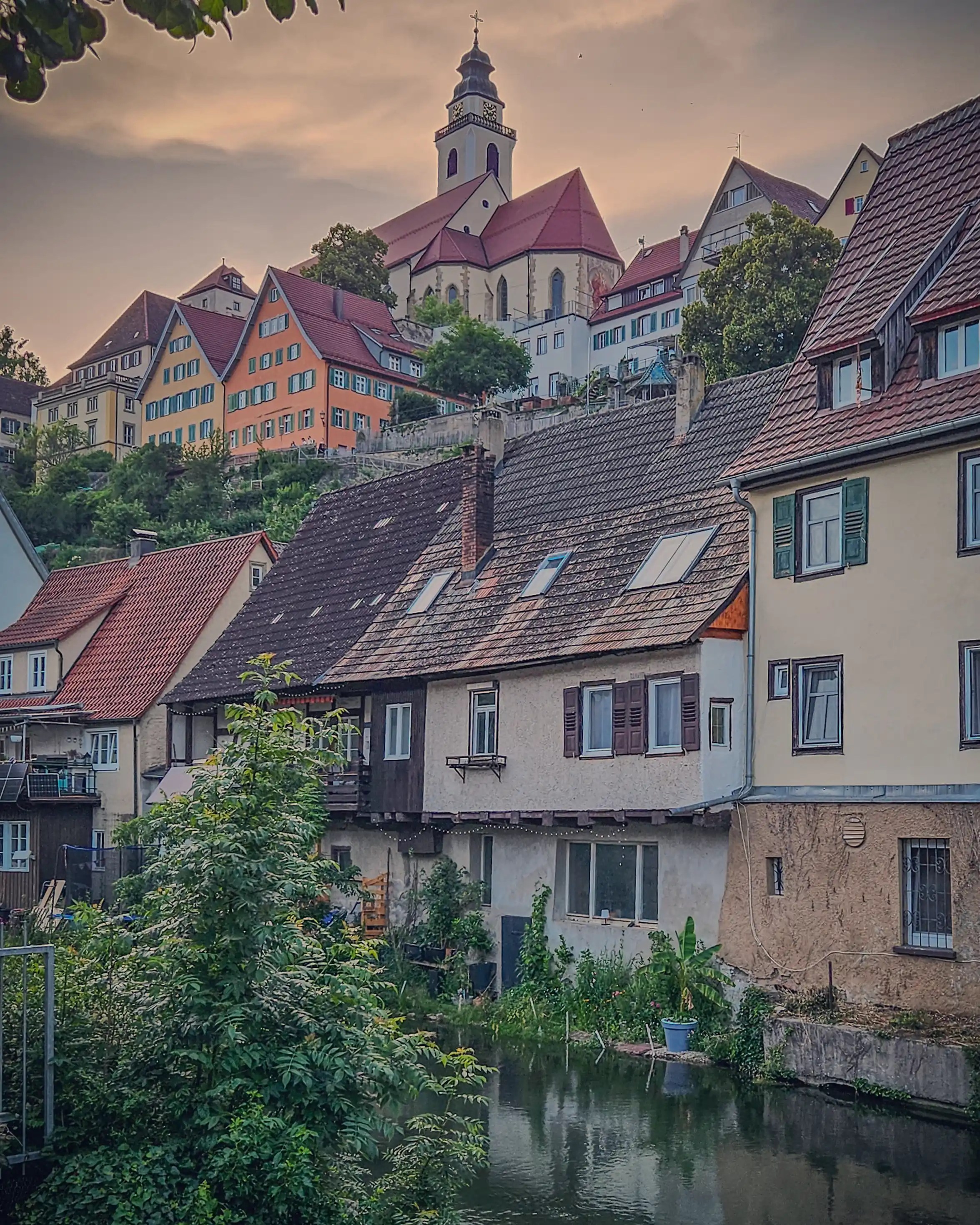 View of Horb am Neckar’s old town from the riverside, showing the church, colorful facades, and homes nestled into the hillside.