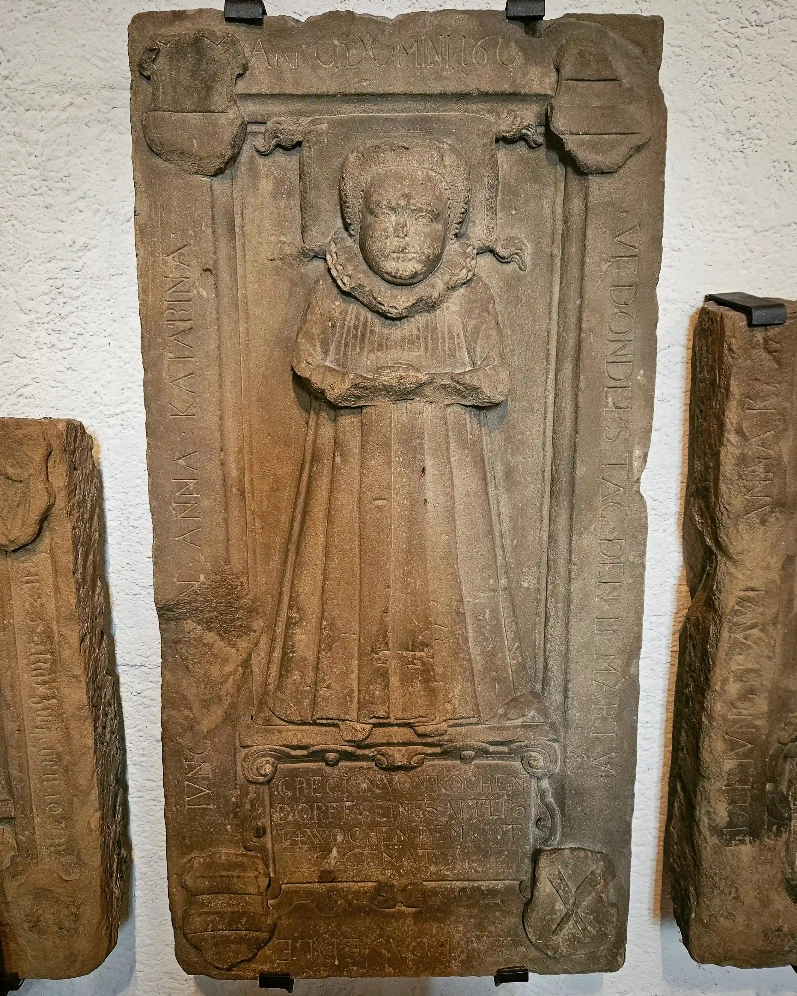 Historic sandstone grave slab inside Sebastianskirche in Bad Friedrichshall, Germany.