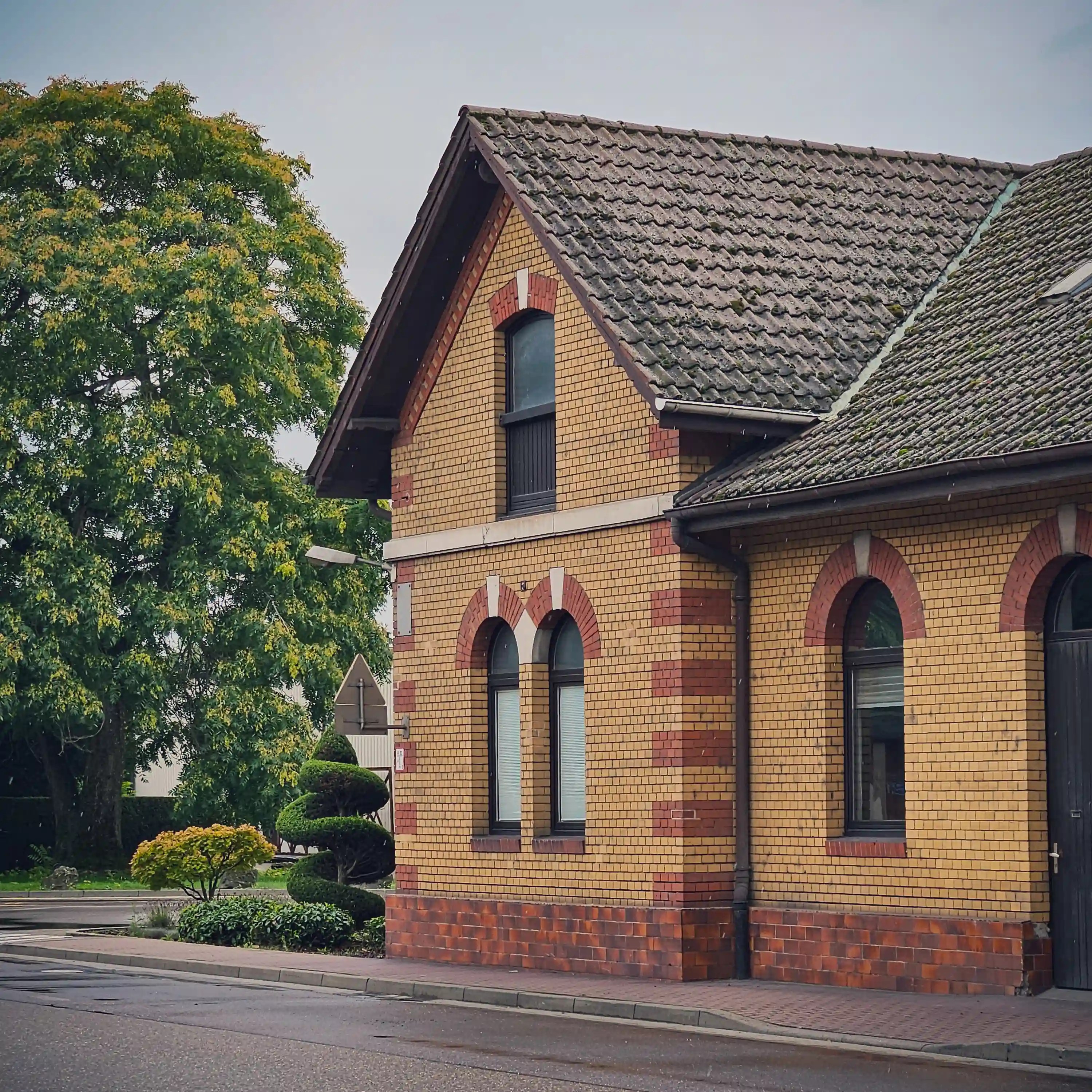 Yellow and red brick building in Bad Friedrichshall with arched windows and gabled roof.