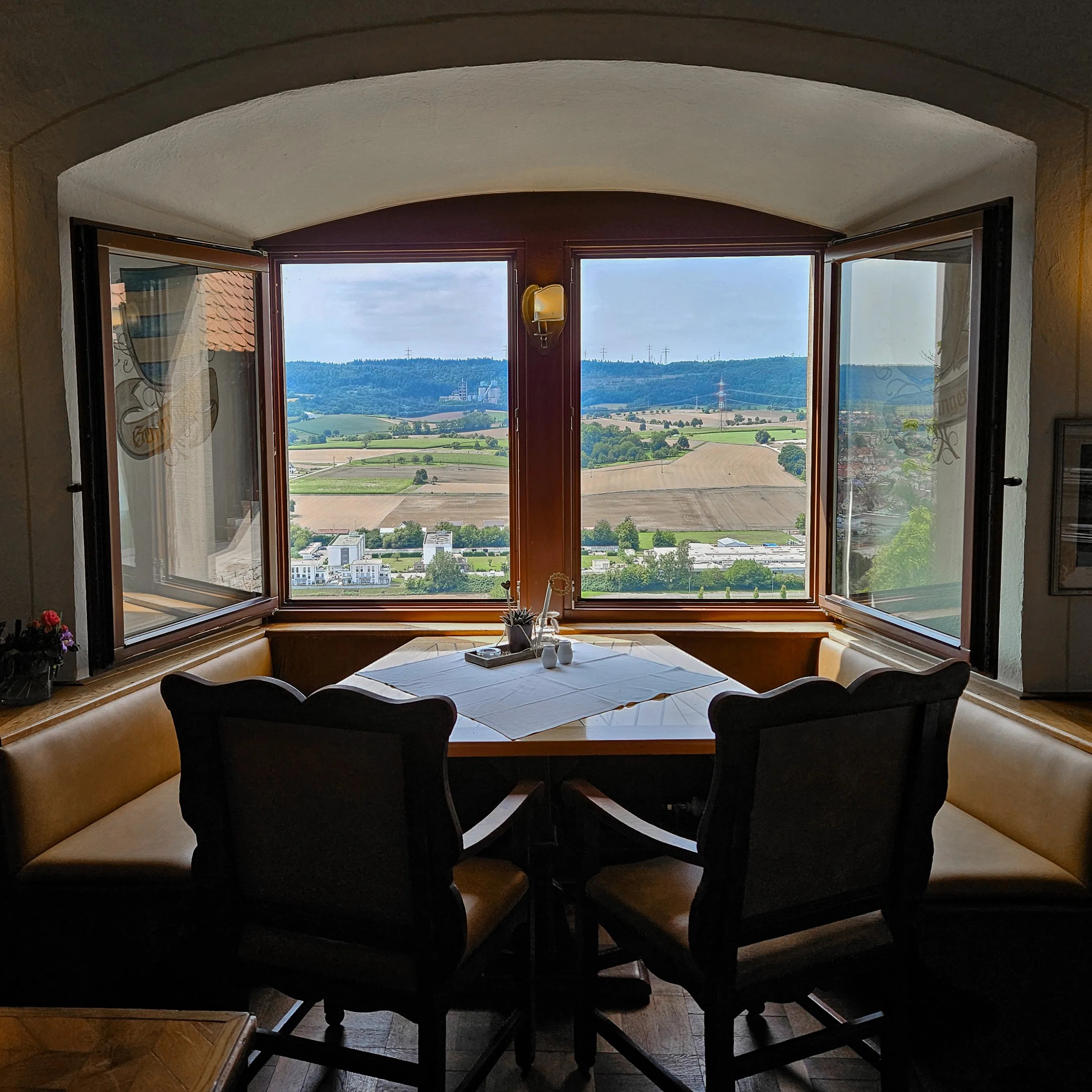 Table by open windows overlooking the Neckar Valley from the Burg Hornberg restaurant.