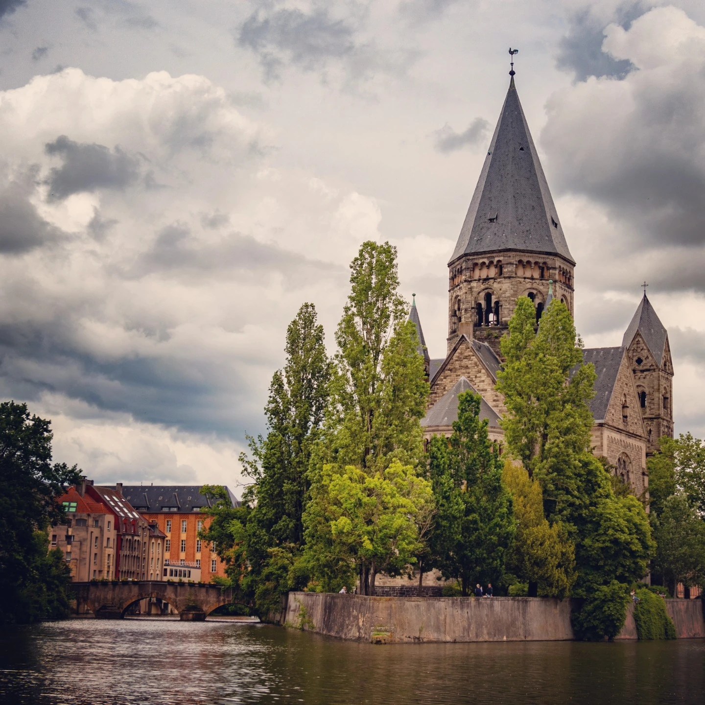 Temple Neuf church in Metz, France, surrounded by trees on an island in the Moselle River.