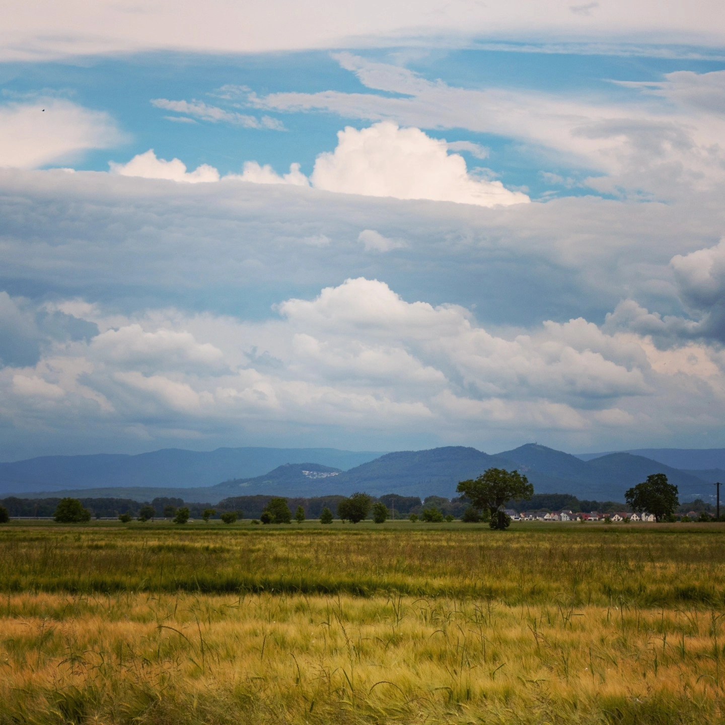 Rolling fields with distant hills and dramatic clouds near Metz, France.