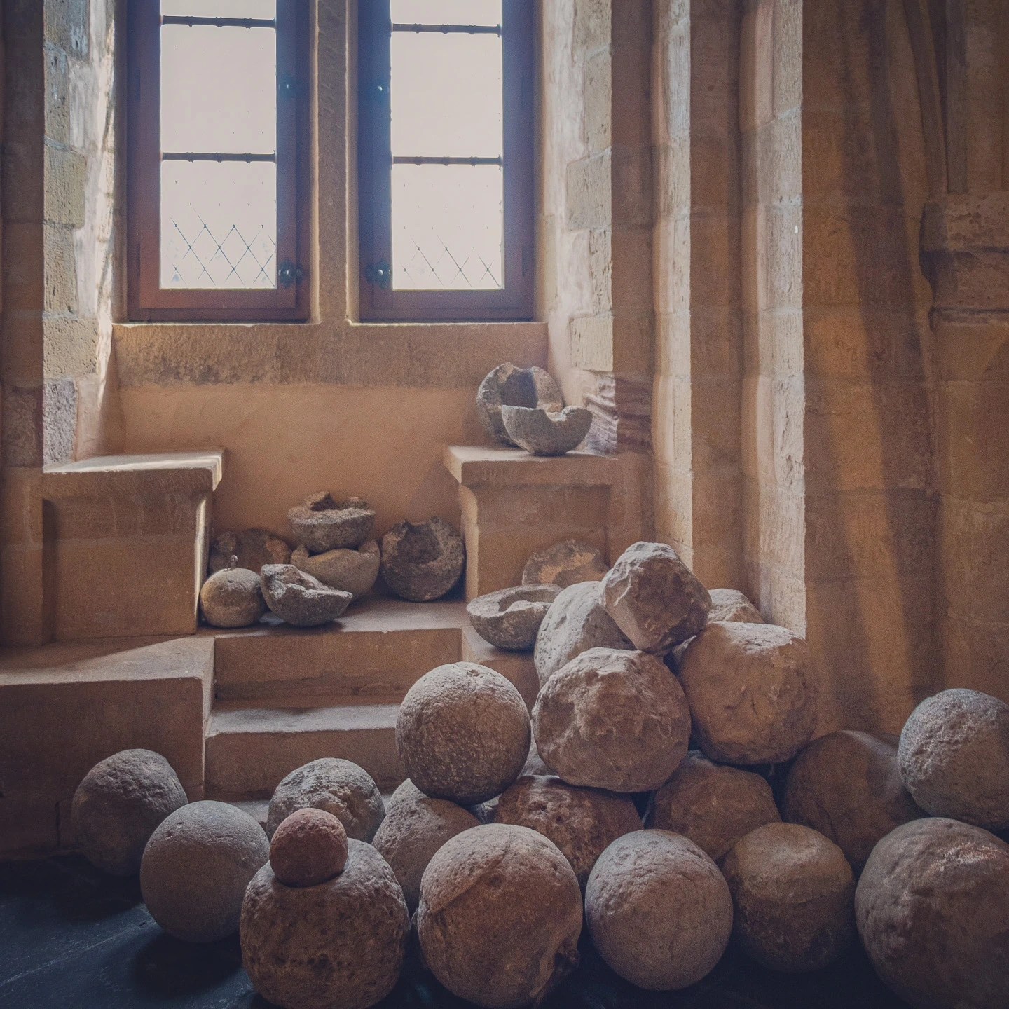 Pile of old stone cannonballs displayed inside Vianden Castle.