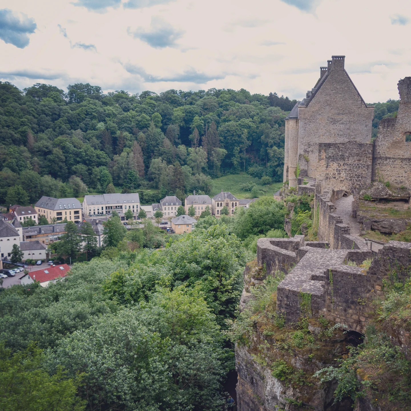 View of Larochette Castle walls perched high above a forested gorge.
