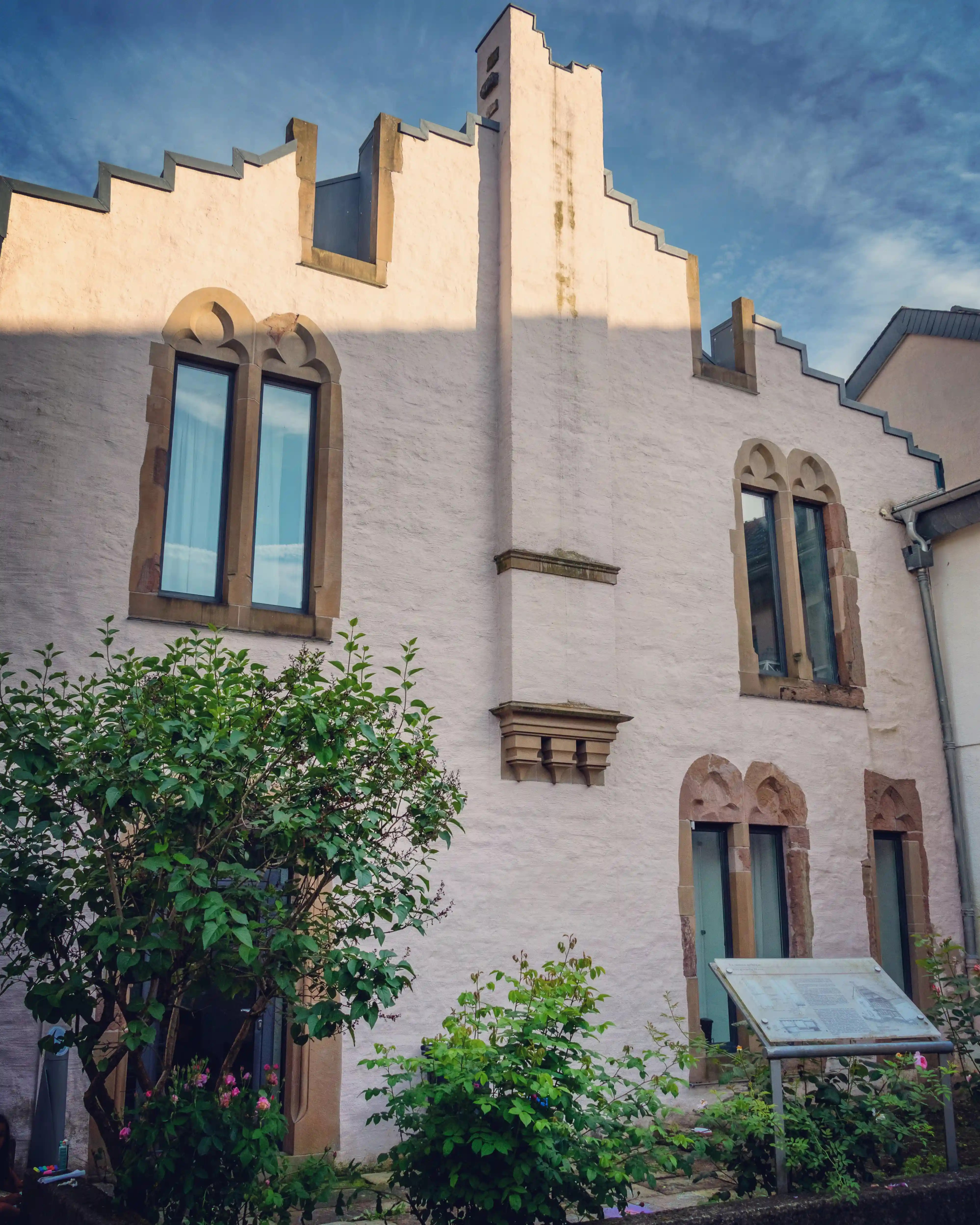 Restored medieval house in Echternach with arched windows and stepped gable.