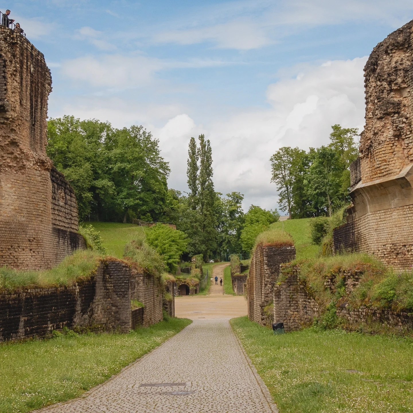 Stone pathway between ruins leading into Trier’s Roman amphitheater.