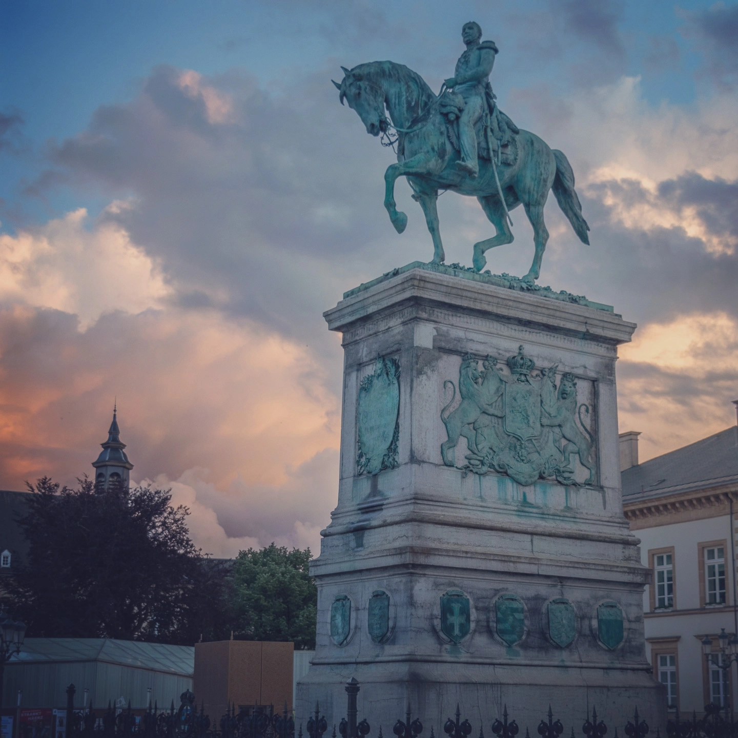 Bronze equestrian statue of Grand Duke William II against a sunset sky in Luxembourg City.
