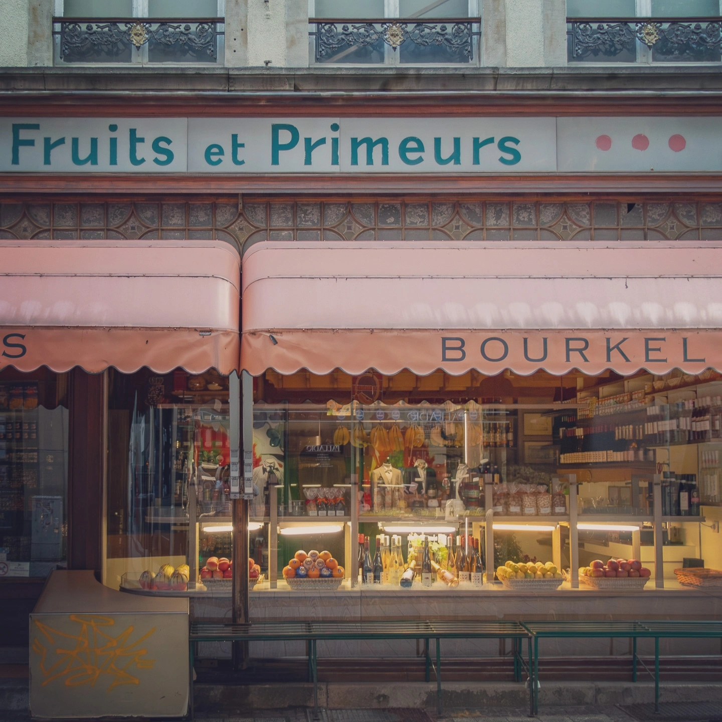 Shopfront of a traditional Luxembourg store with fruits, wines, and French signage.