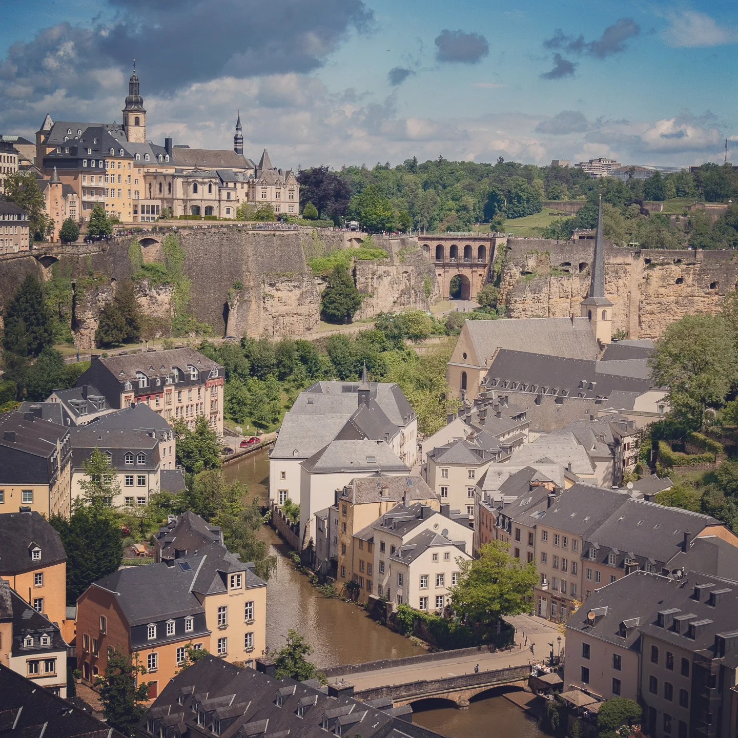 Luxembourg City’s old town with pastel houses, stone cliffs, and fortified walls.