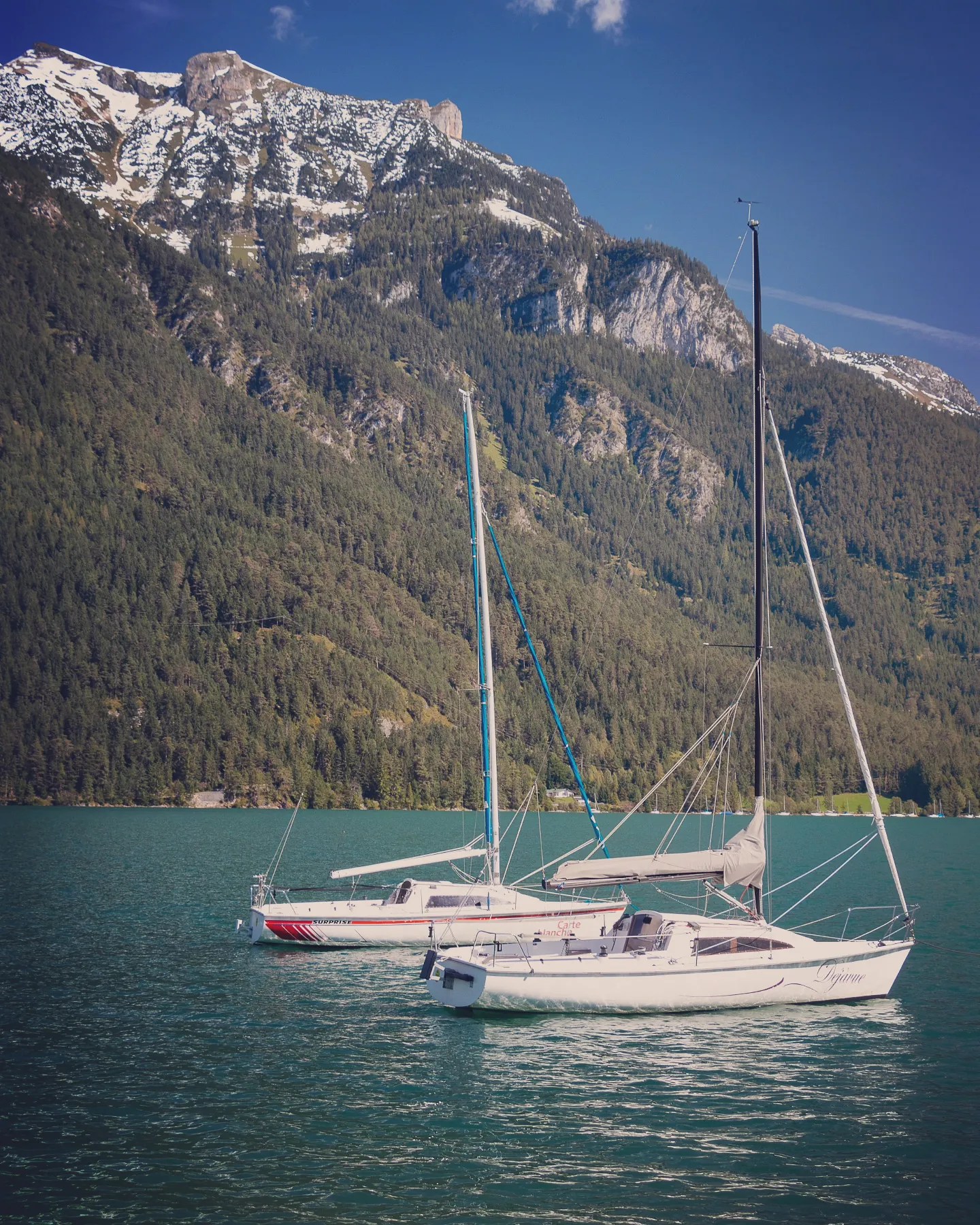 Sailboats floating on Lake Achensee with the mountains behind, Pertisau, Tyrol.
