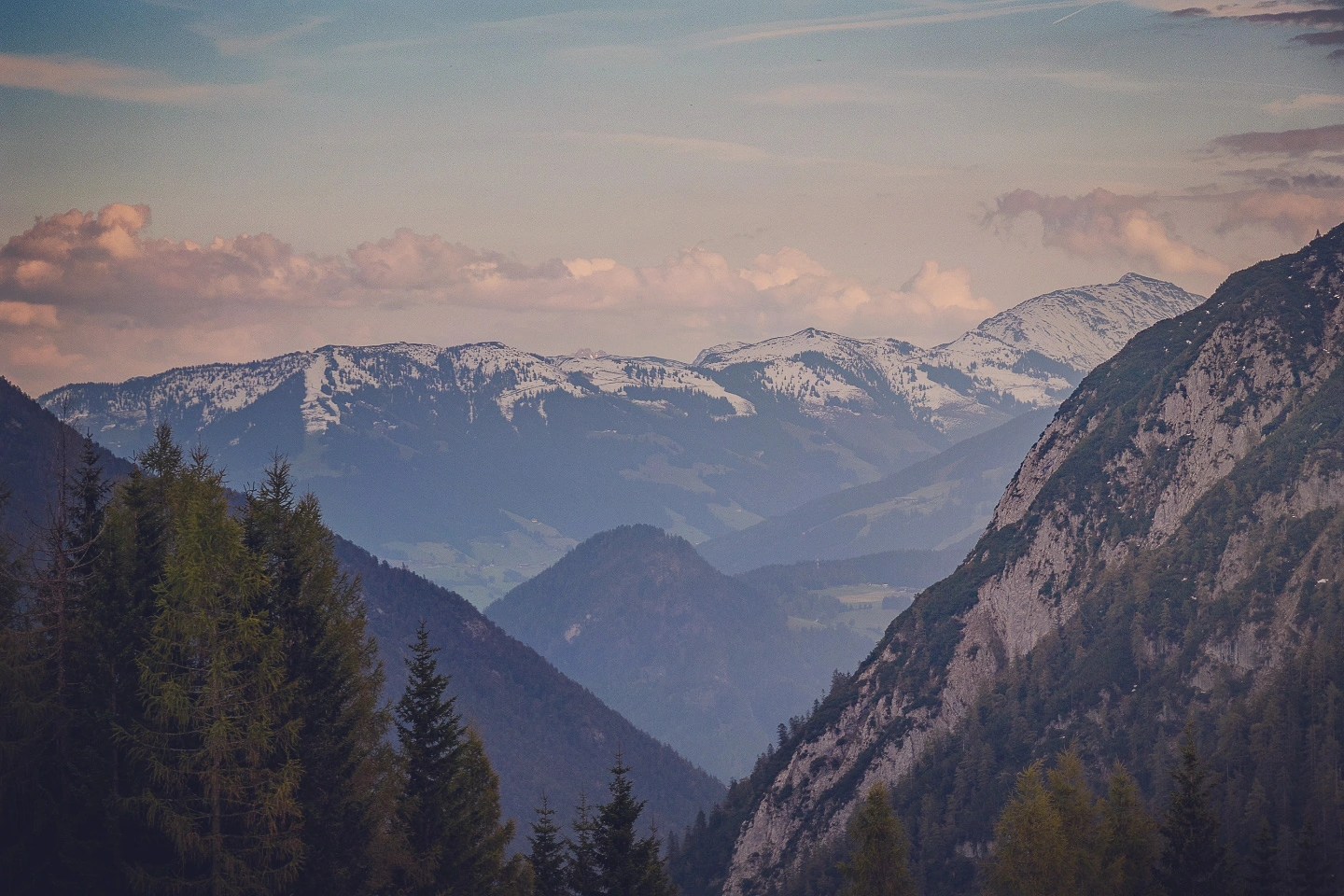 Layered Tyrolean ranges with snow patches and pines at dusk near Achensee.