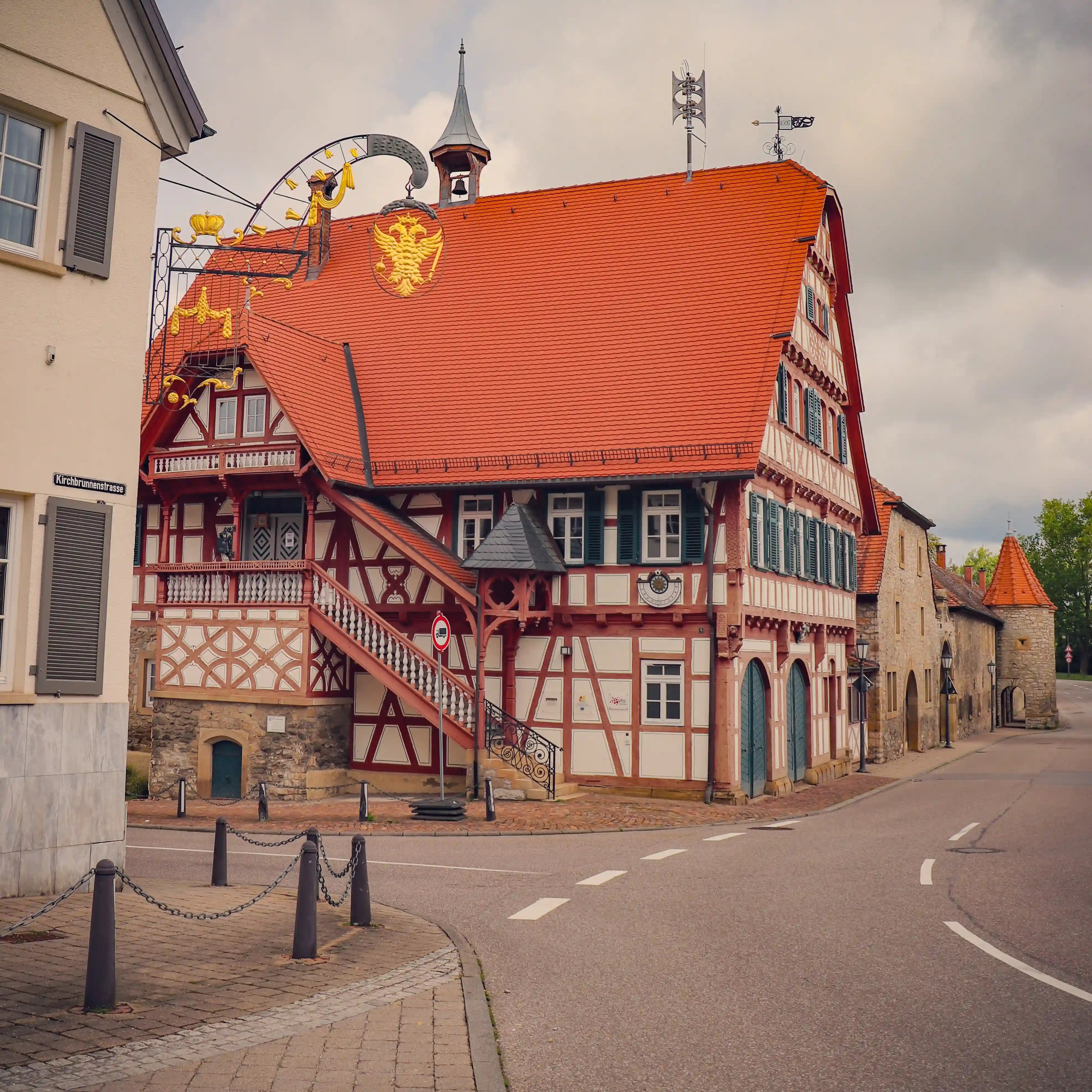 Traditional half-timbered building with red roof and a decorative sign in Bad Friedrichshall.