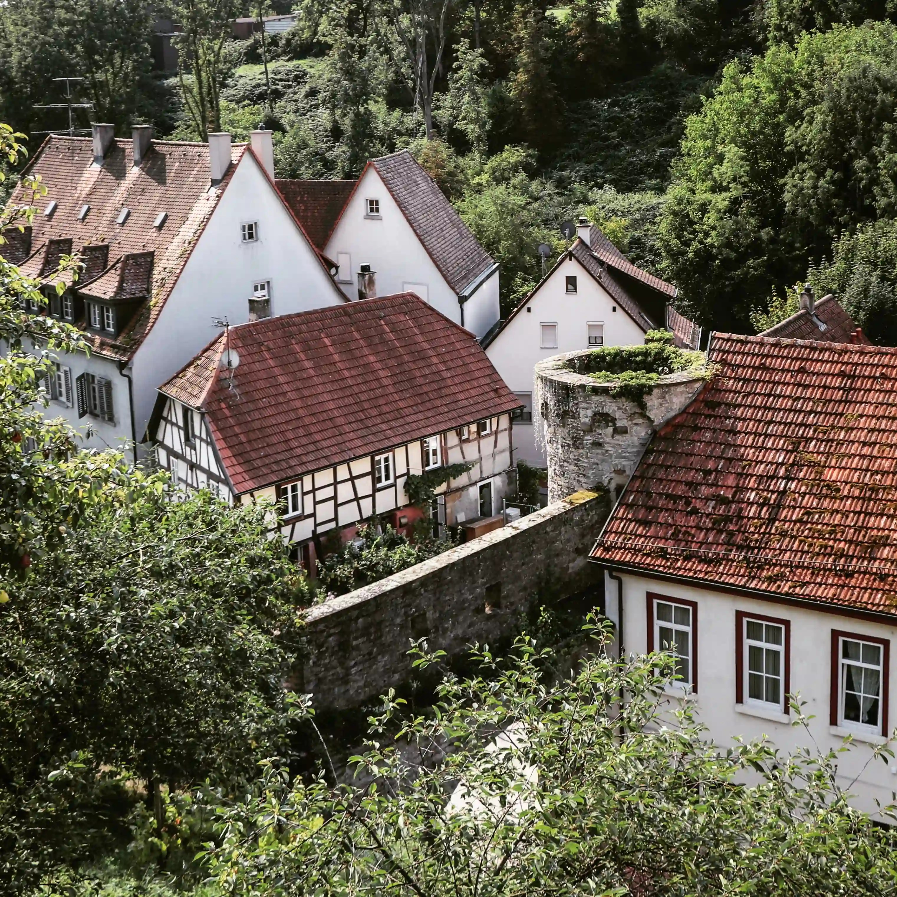 Cluster of white houses and a round wall tower viewed from above, Bad Wimpfen old town.