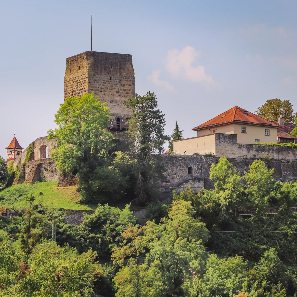 Square stone keep and hilltop fortifications of Bad Wimpfen’s former imperial palace (Red Tower) rising above the trees.