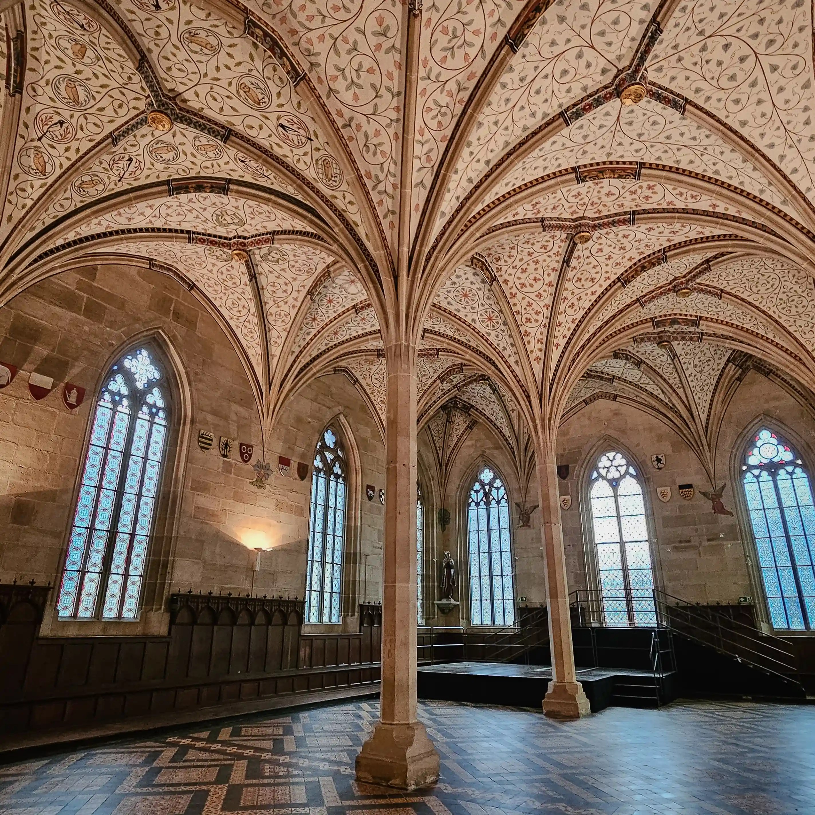 Gothic hall with ribbed vaulted ceiling painted in floral patterns at Bebenhausen Monastery.