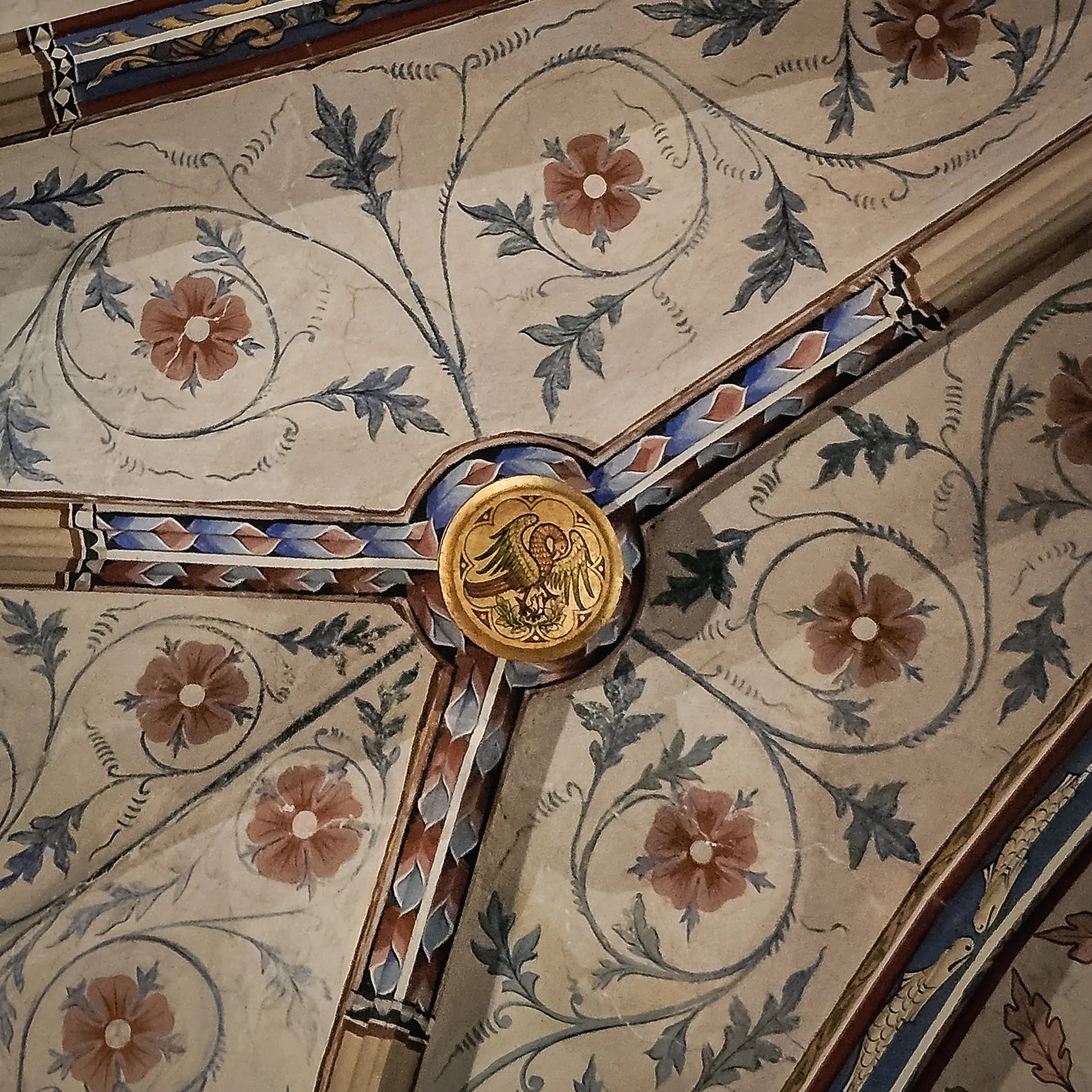 Painted ceiling detail at Bebenhausen with floral vines and a golden medallion featuring an phoenix.