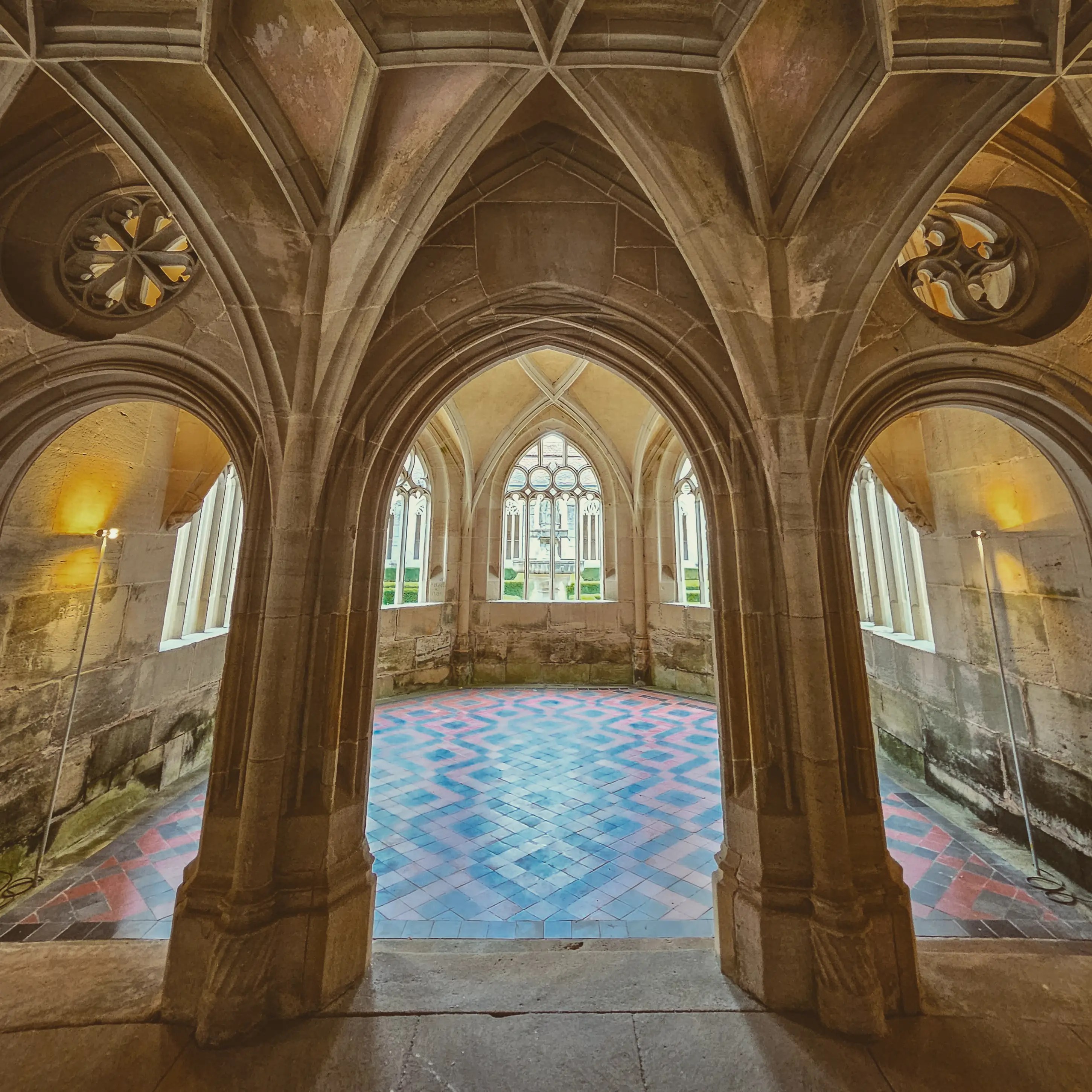Stone archway leading to octagonal room with tiled floor at Bebenhausen Monastery.