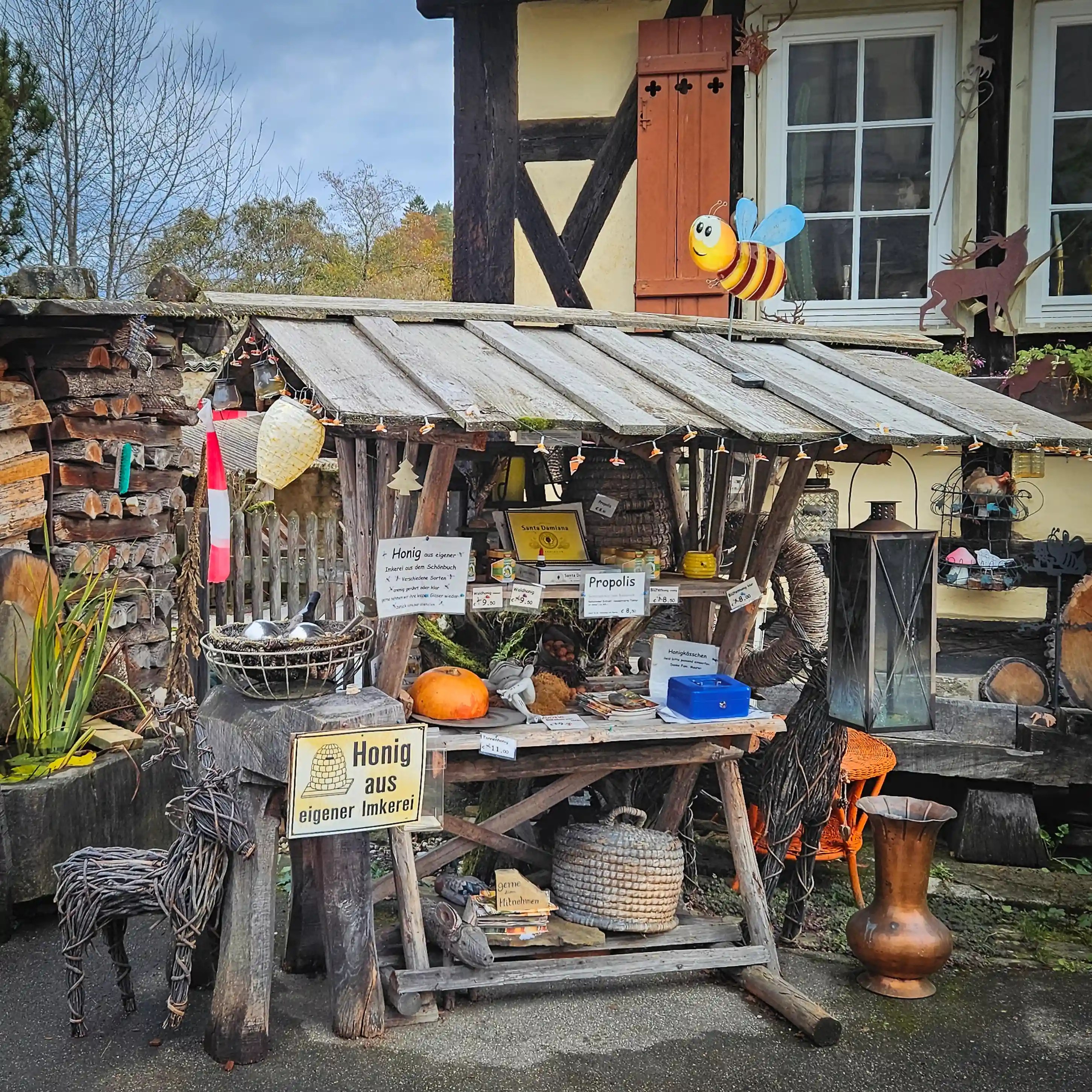 Rustic honey stand decorated with wooden figures in Bebenhausen.