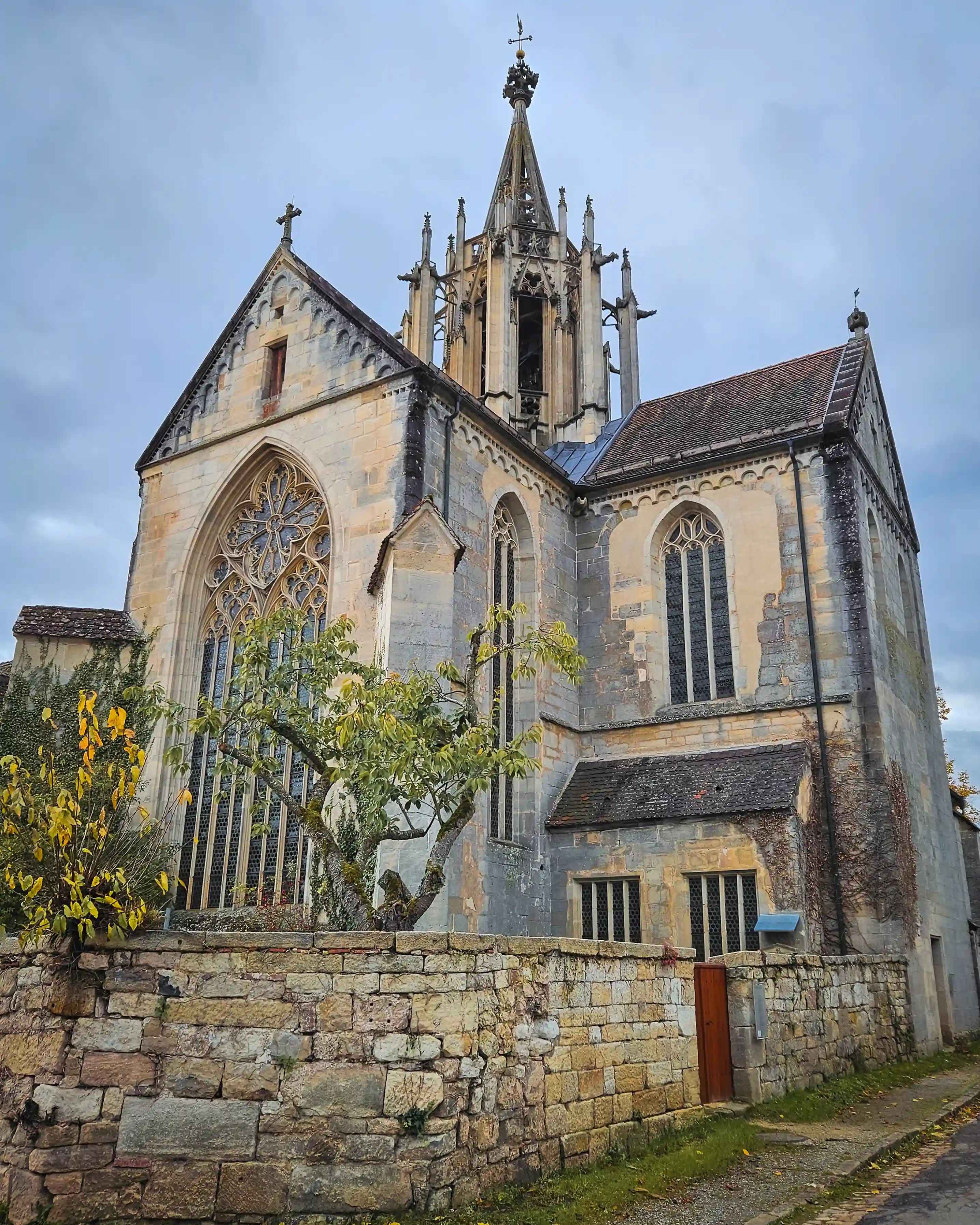 Gothic abbey church of Bebenhausen with tall spire and stone wall.