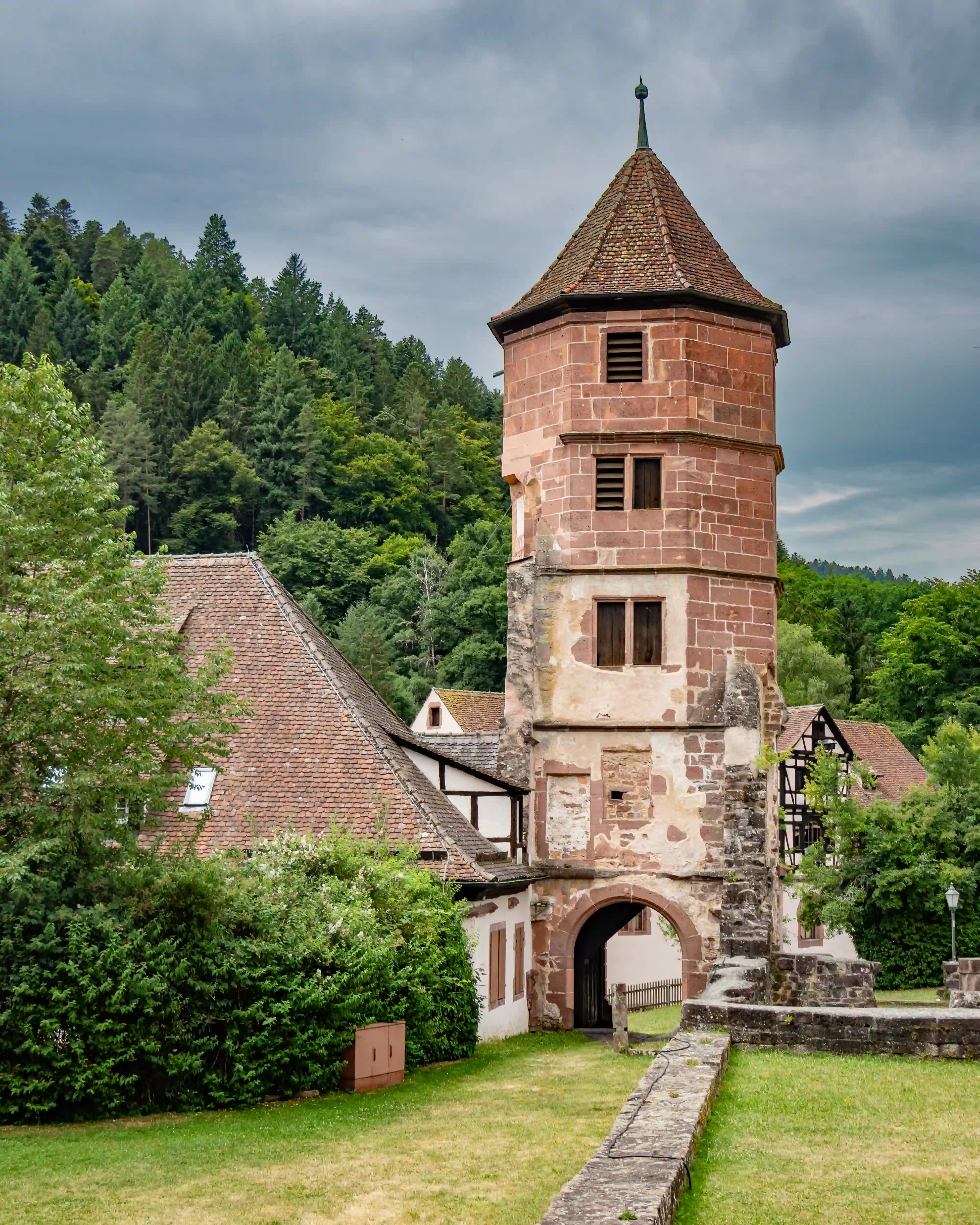 Octagonal red sandstone tower with arched gateway at Hirsau Monastery.