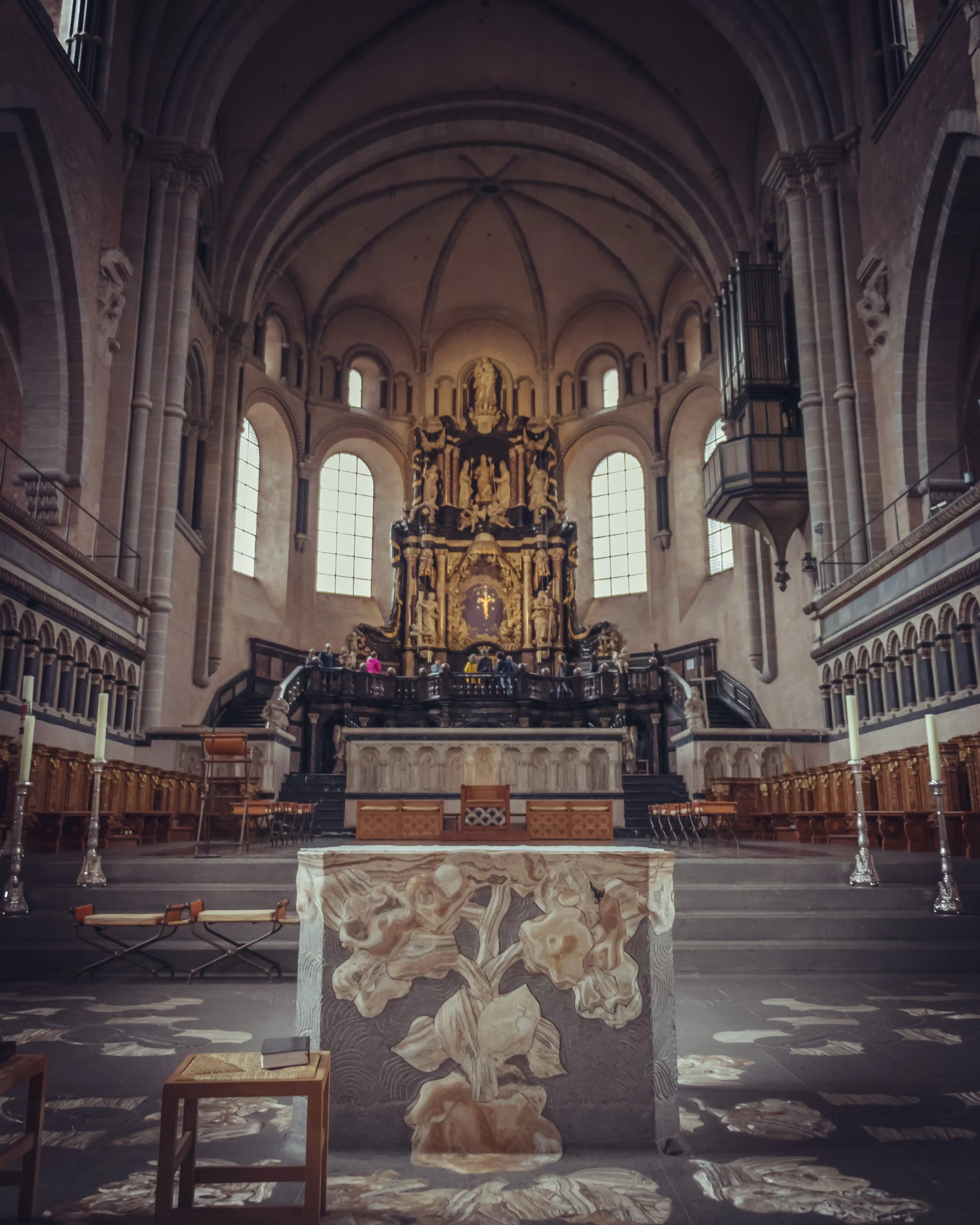 View of Trier Cathedral’s ornate Baroque altar with sculpted details and a modern stone altar in the foreground.