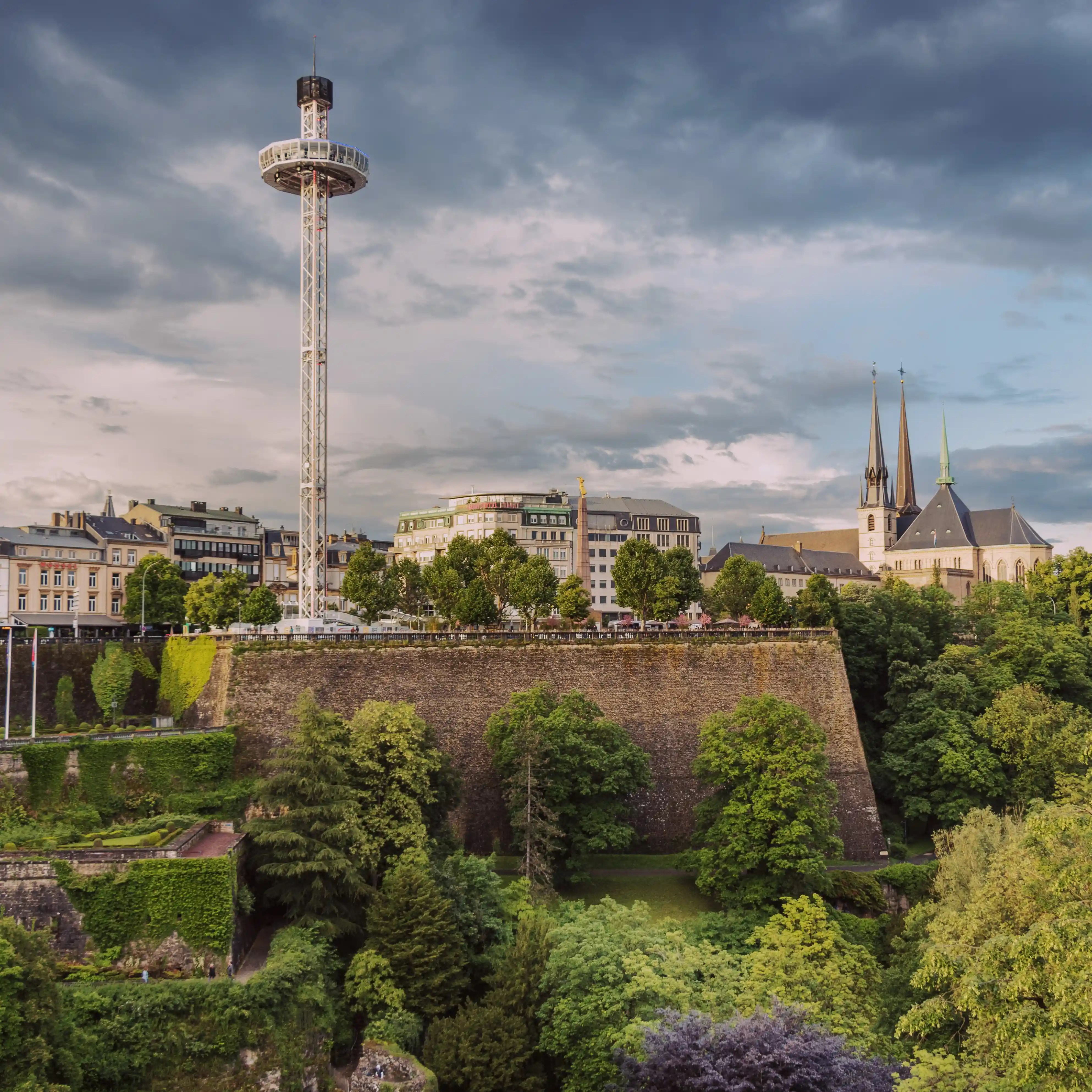 City view of Luxembourg with the City Skyliner tower, historic buildings, and the spires of Notre-Dame Cathedral rising above the old fortress walls.