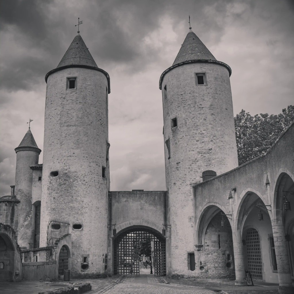 Black-and-white photo of the interior gate of the Porte des Allemands, showing twin towers and a heavy portcullis.