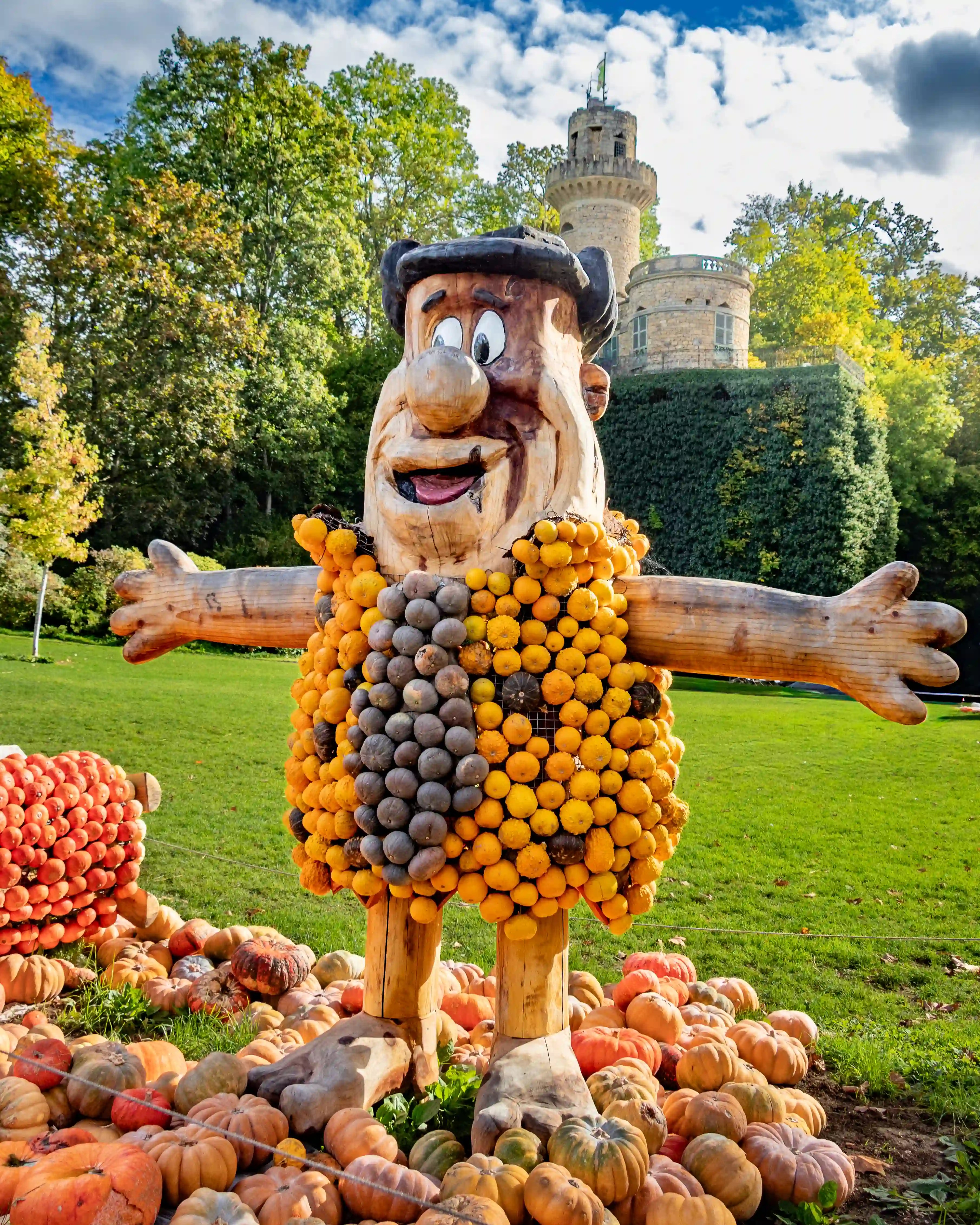 Pumpkin sculpture of Fred Flintstone with the Emichsburg tower in the background.