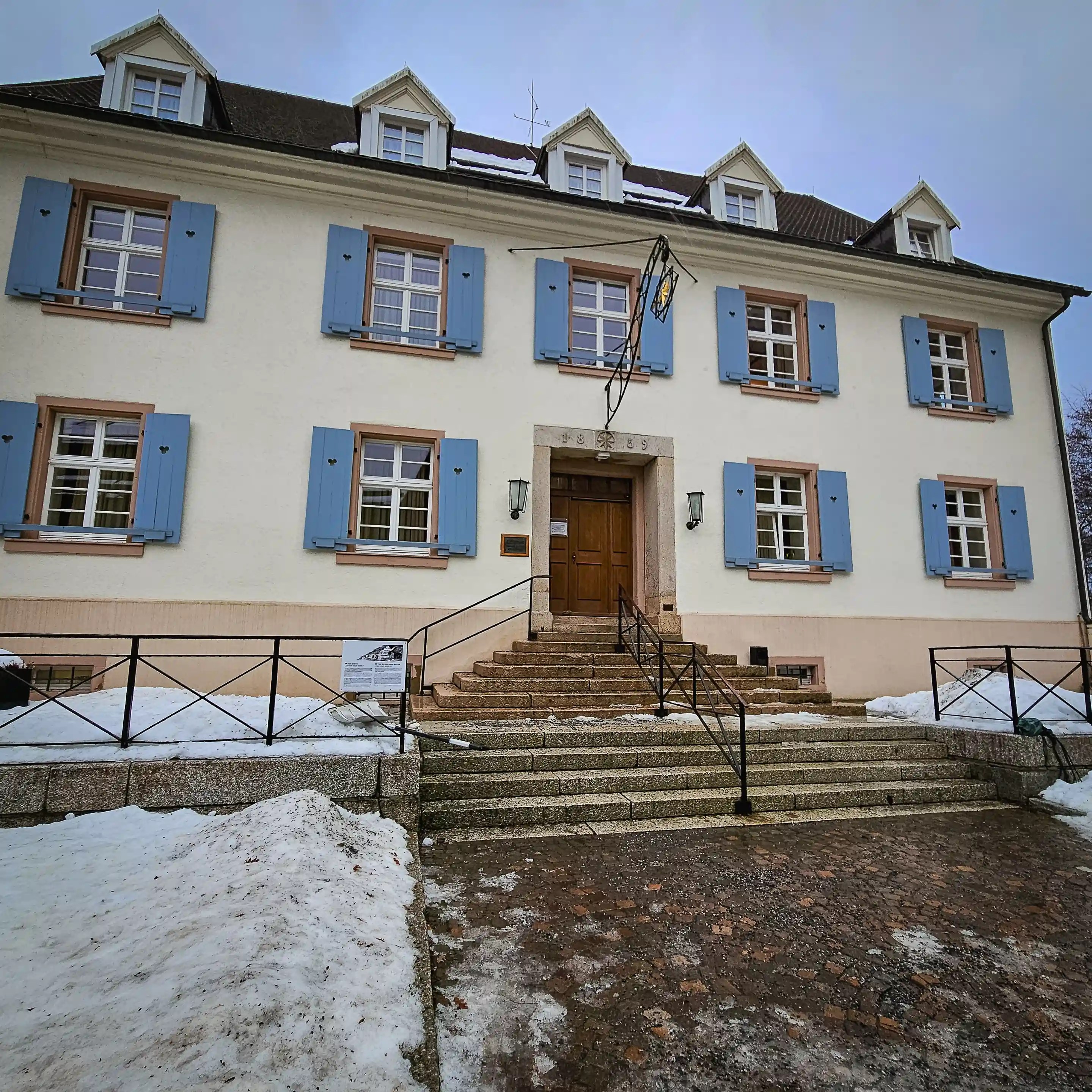 Cream-colored building with blue shutters known as Goethehaus at Hofgut Sternen, named after the famous poet Johann Wolfgang von Goethe.