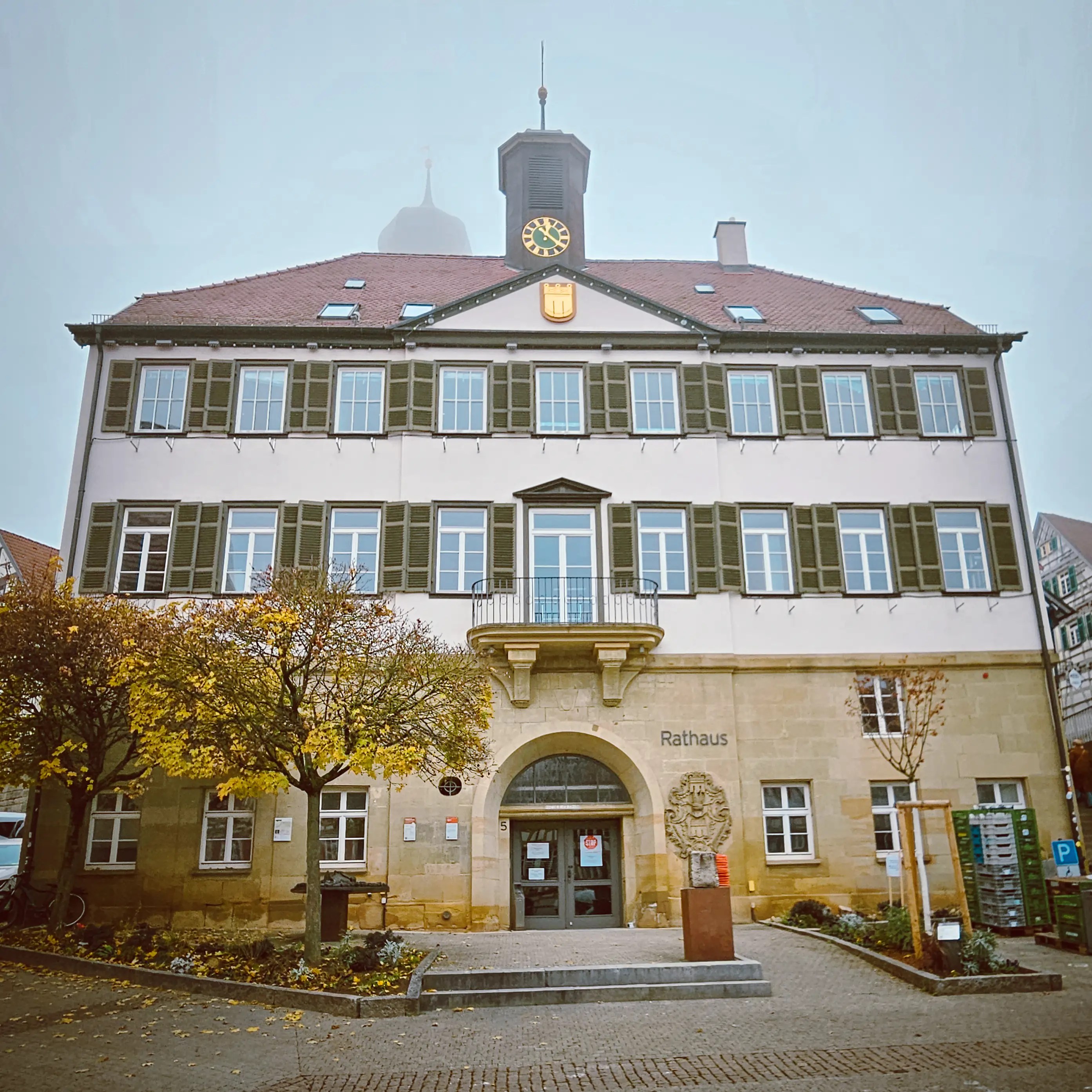 The Herrenberg Rathaus with its clock tower and autumn trees in front.