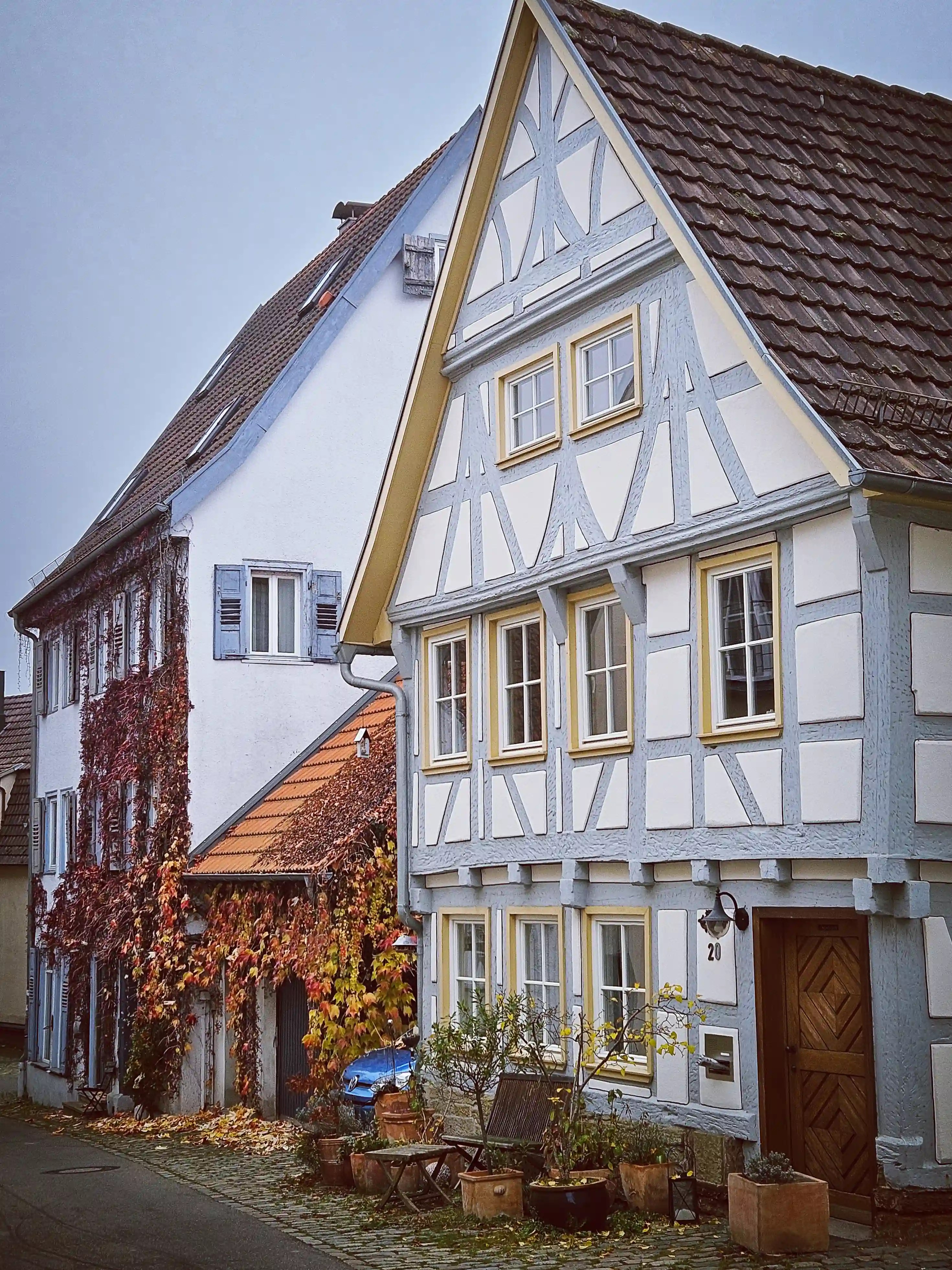 Row of half-timbered and ivy-covered houses on a quiet cobblestone street in Herrenberg.