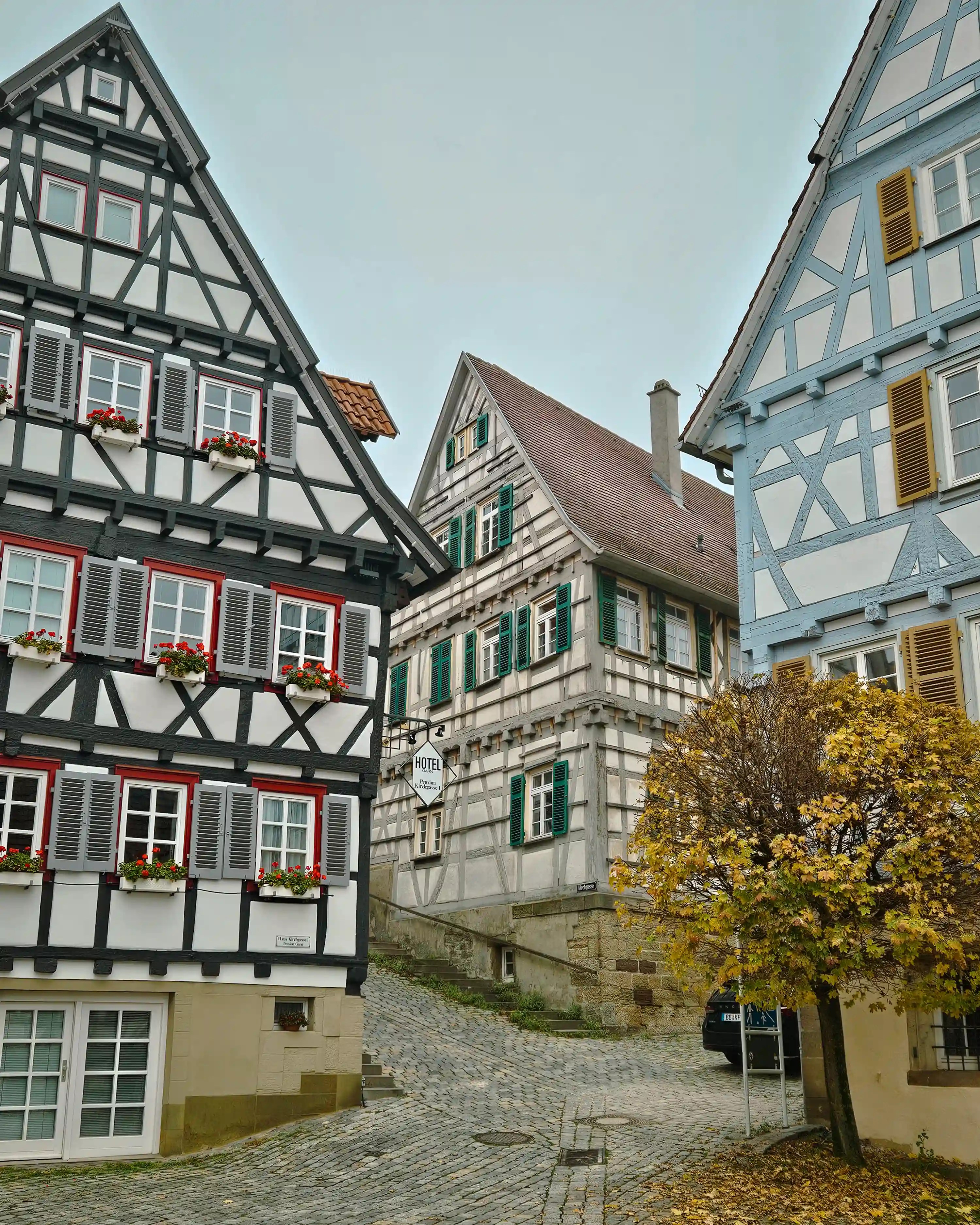 Narrow cobblestone street lined with colorful half-timbered houses in Herrenberg.