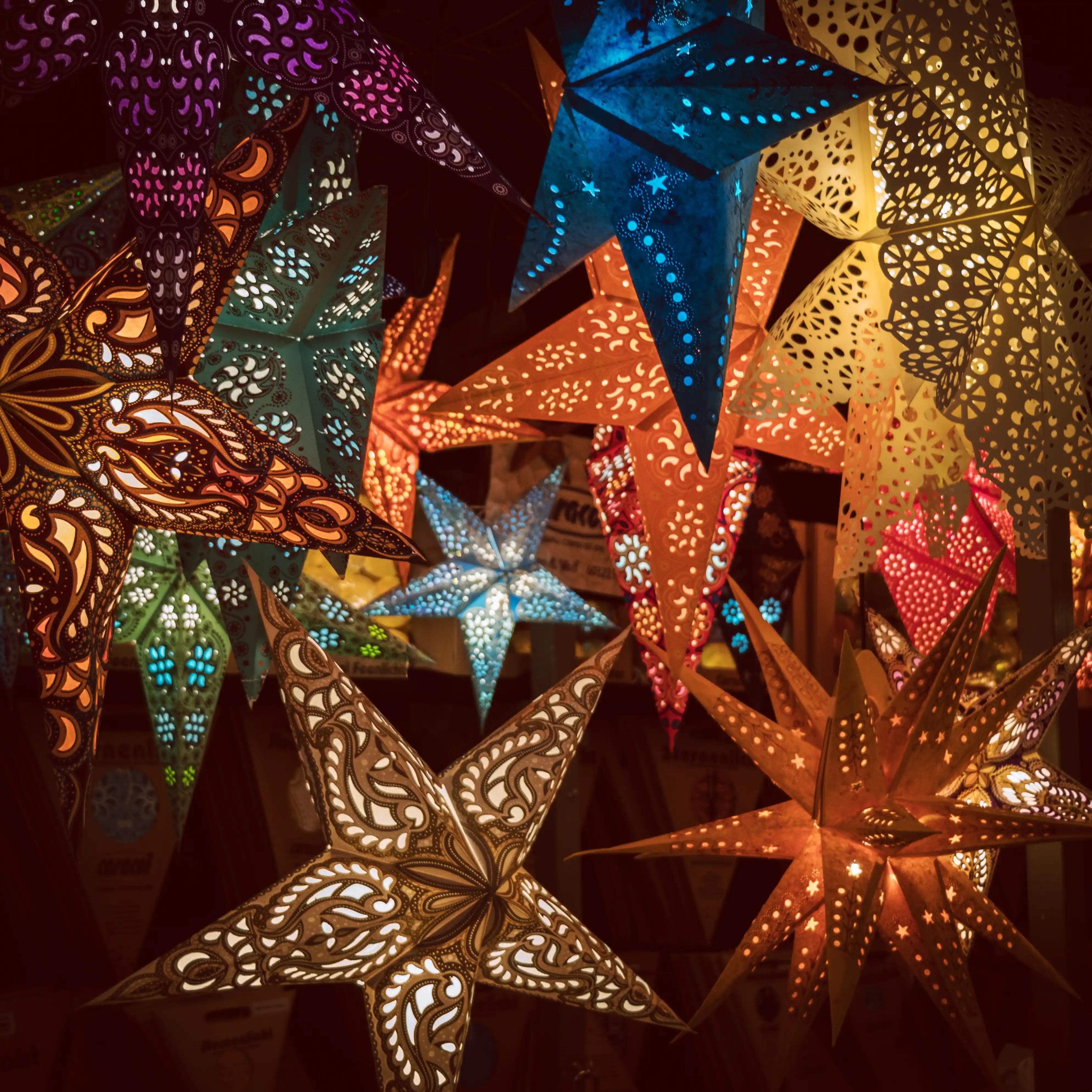 Colorful paper star lanterns illuminated at a Christmas market stall in Rothenburg ob der Tauber.