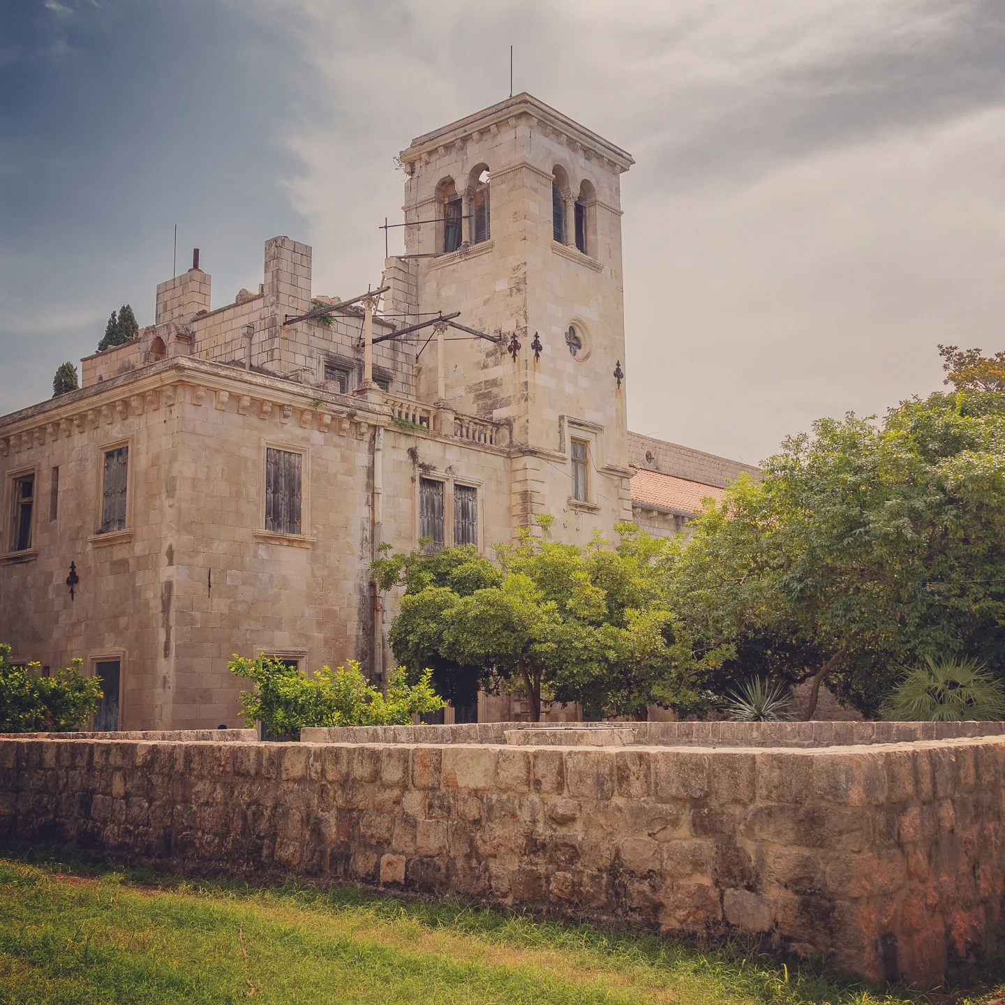 Stone ruins of the Benedictine Monastery on Lokrum Island surrounded by trees.