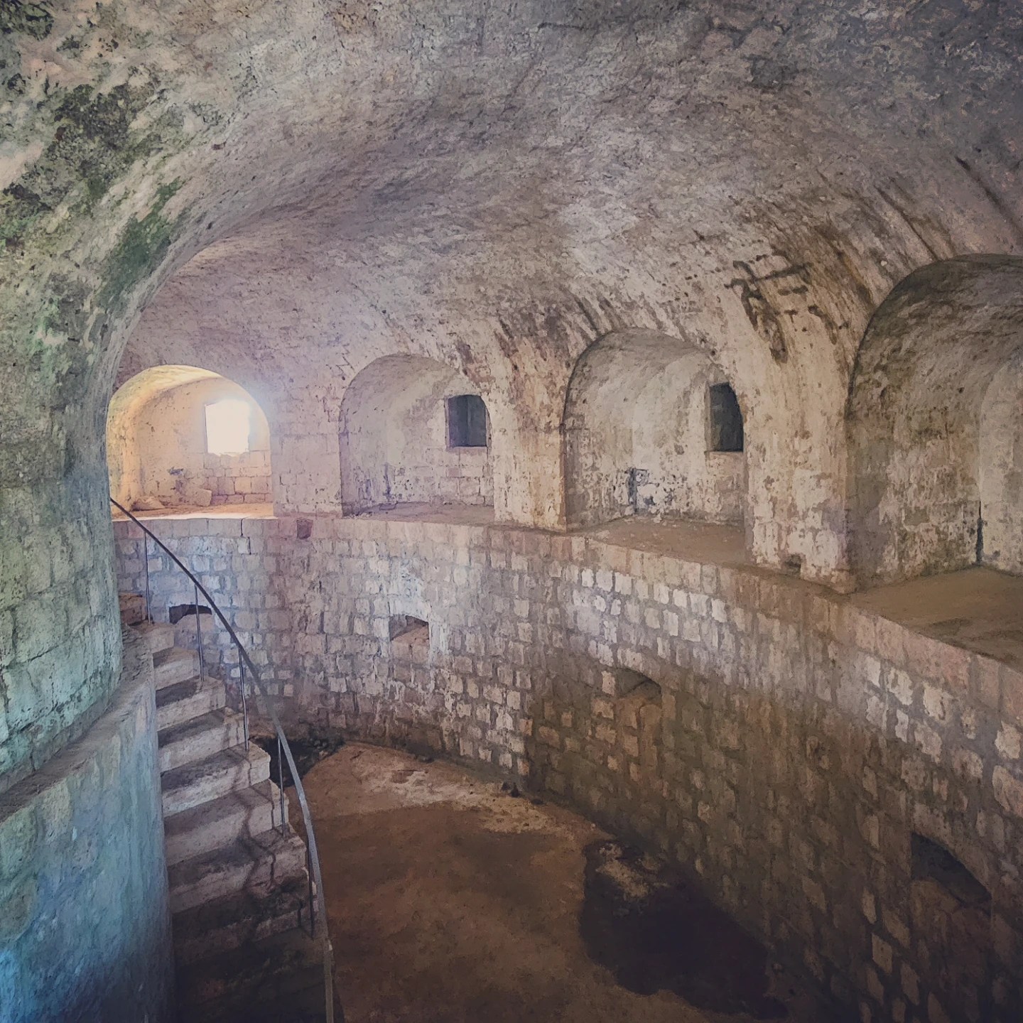 Stone interior of Fort Royal on Lokrum Island with arched chambers and spiral stairs.