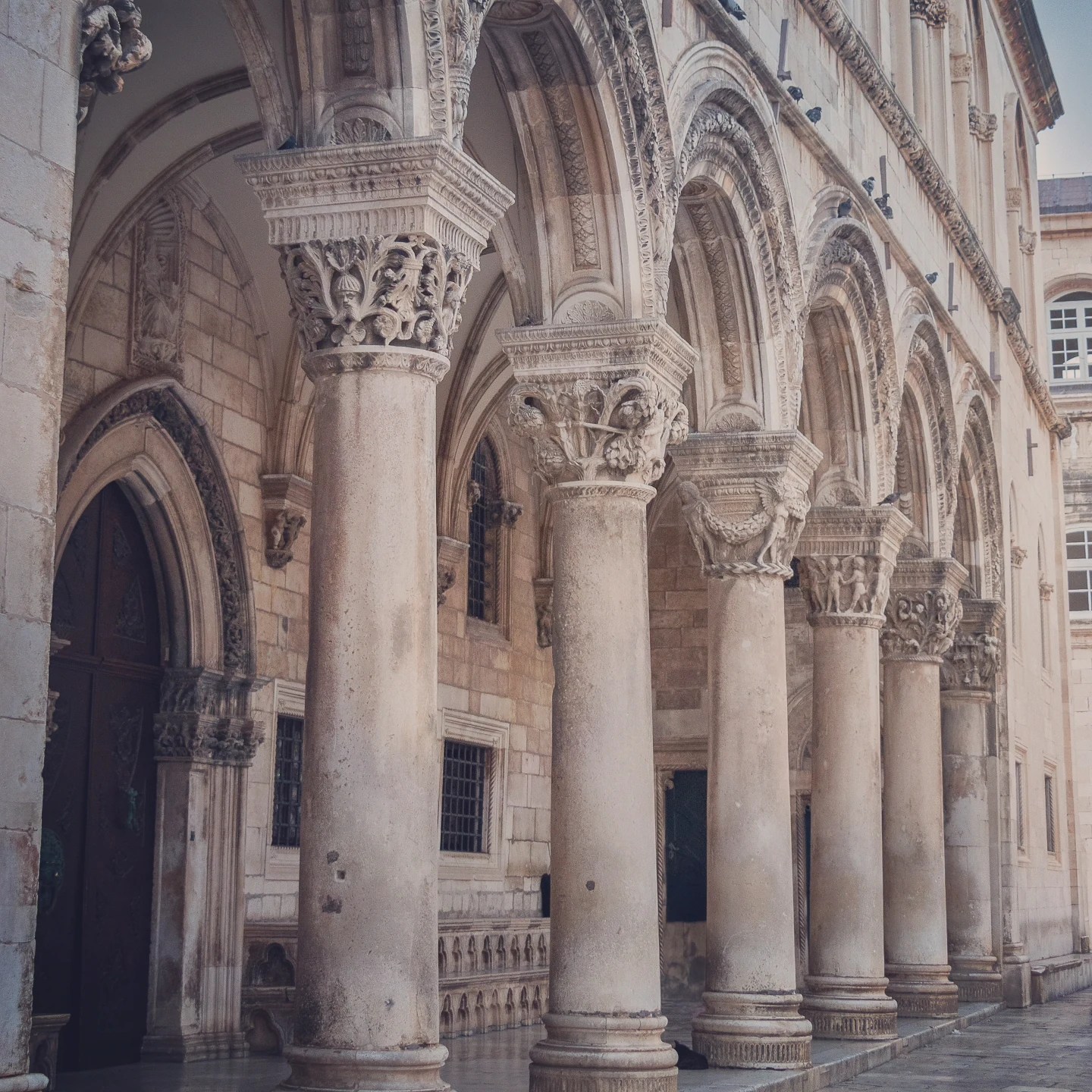 Stone arches and carved columns of the Rector’s Palace in Dubrovnik.