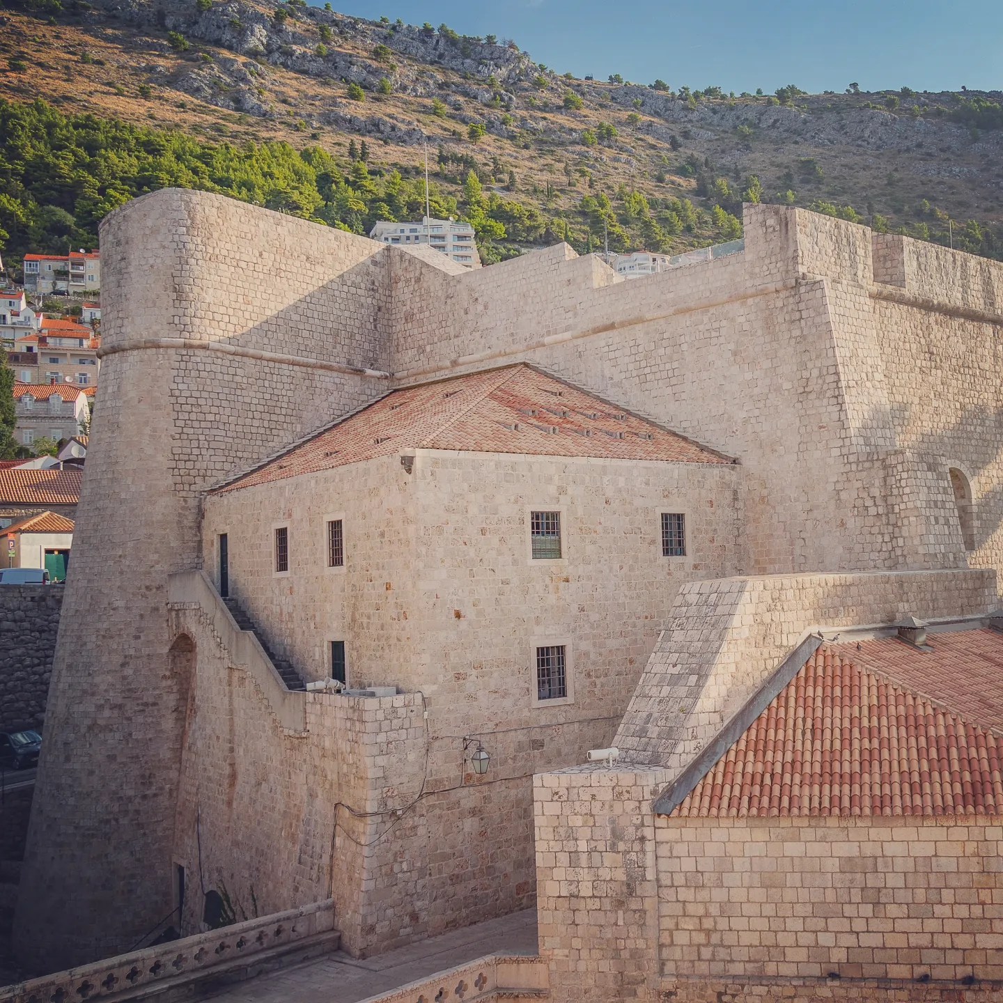 Massive stone walls and rooftops of Fort Revelin in Dubrovnik.