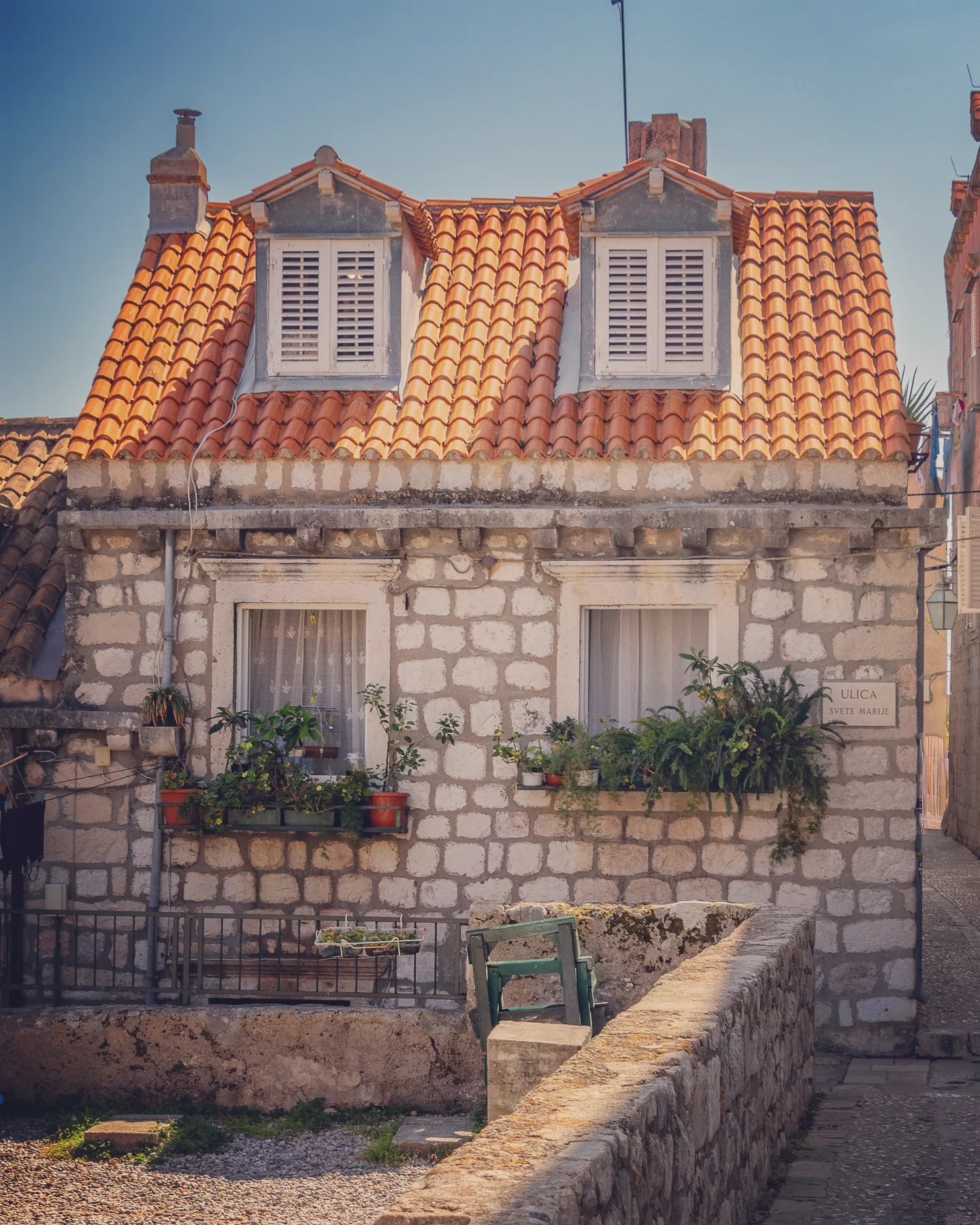 Small stone house with terracotta roof and potted plants on Ulica Svete Marije in Dubrovnik.